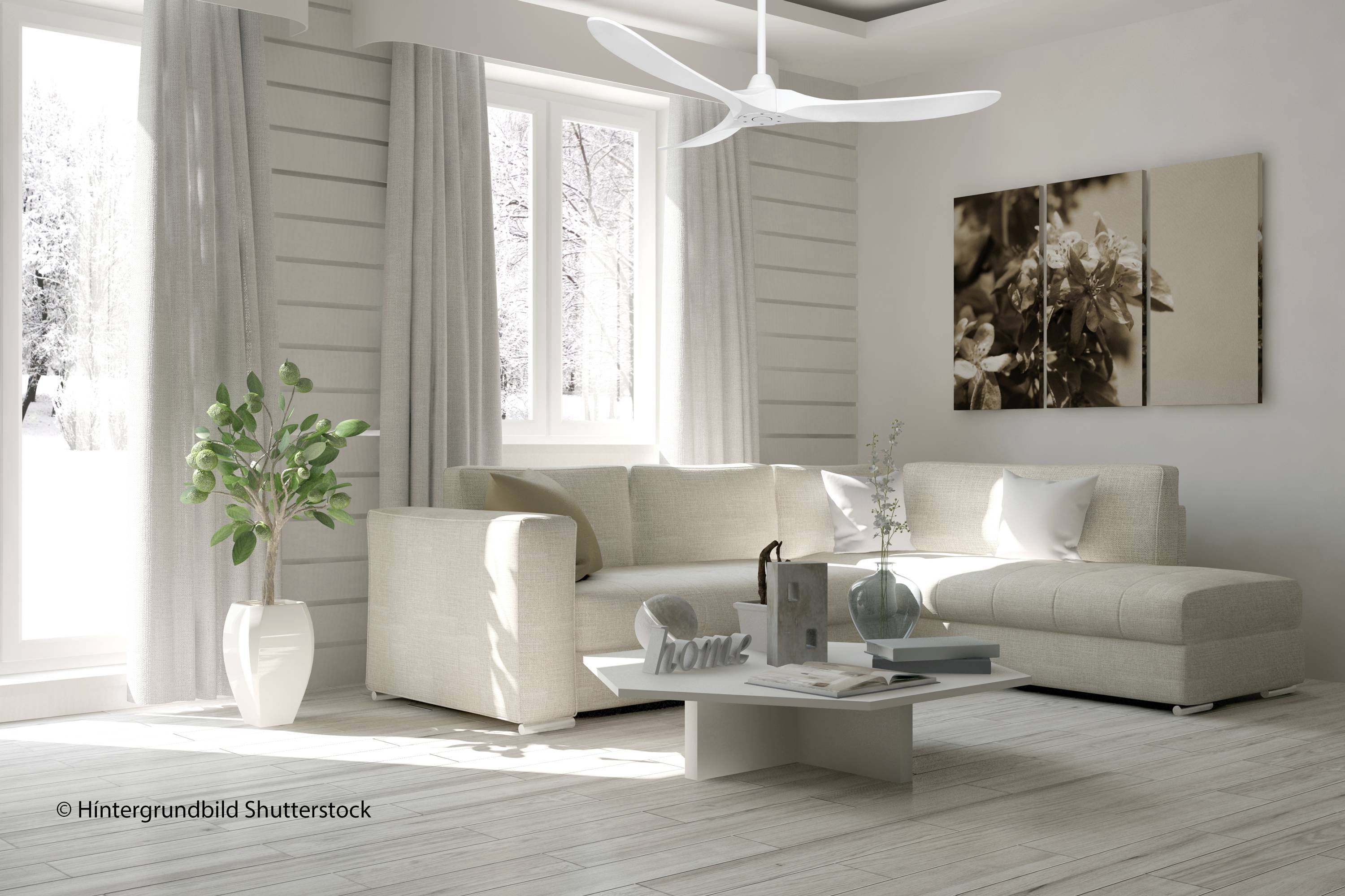 Helles Wohnzimmer mit großem Sofa, Couchtisch mit Dekoration, Pflanzen und großen Fenstern mit winterlichem Ausblick.