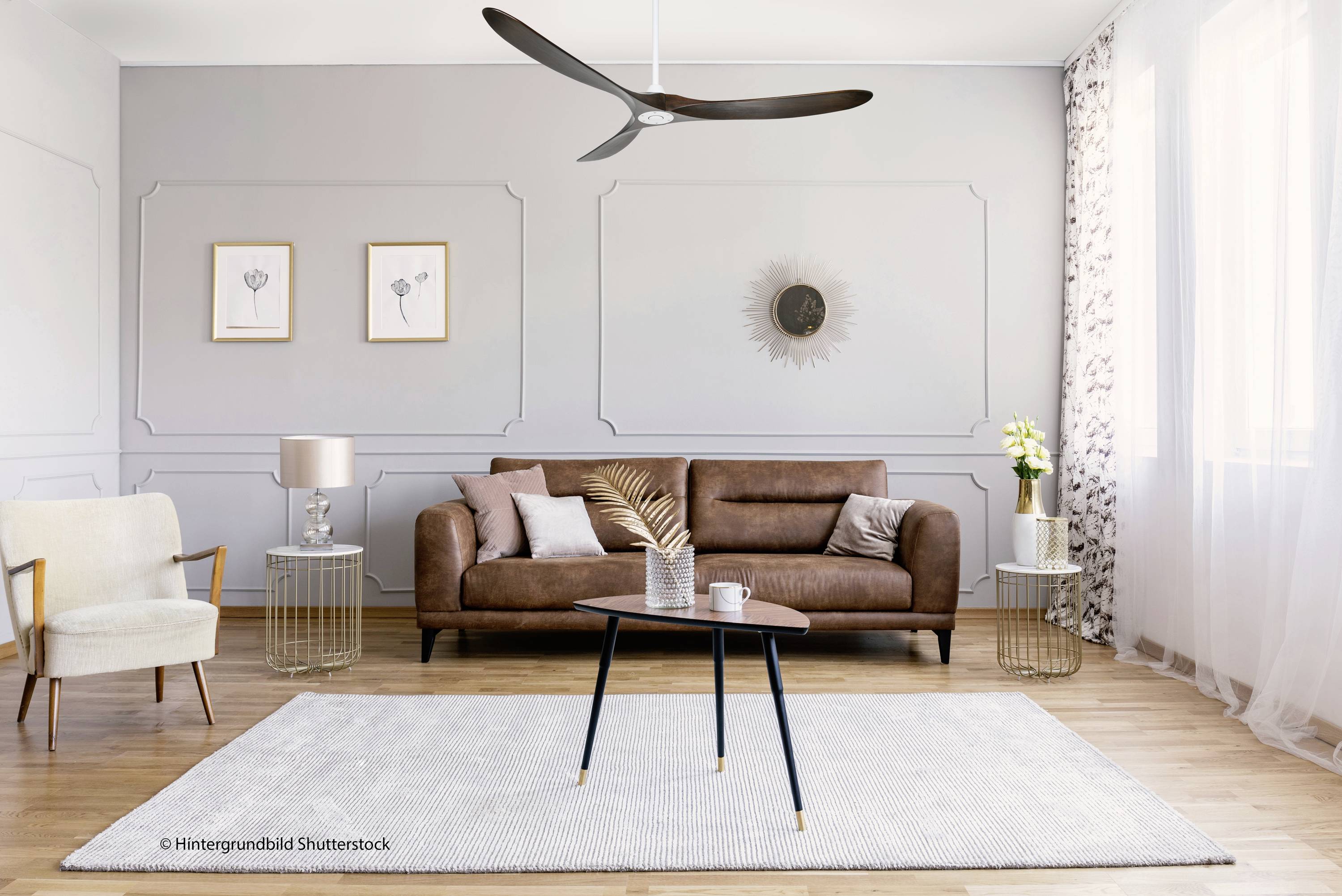 Ein modern eingerichtetes Wohnzimmer mit braunem Ledersofa, beige Sessel, rundem Couchtisch, hellgrauem Teppich und eleganter Dekoration.