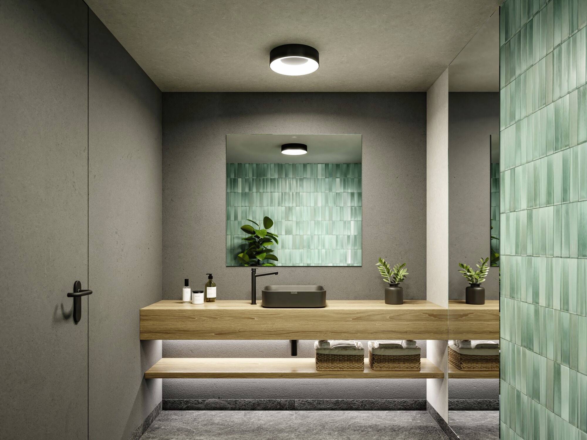 Moderne Badezimmeransicht: Wand aus grünen Fliesen, hölzerne Arbeitsplatte mit schwarzem Waschbecken, zwei Pflanzen, dezentes Licht.