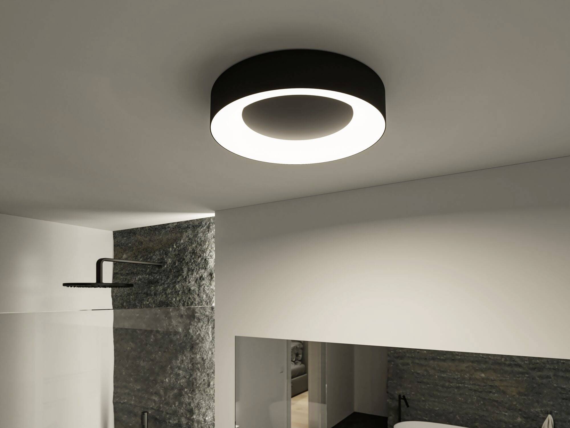 Ein modernes Badezimmer mit einer runden, dunklen Deckenleuchte, die hell erleuchtet ist. Sichtbar sind eine Dusche und ein Teil des Waschbereichs.