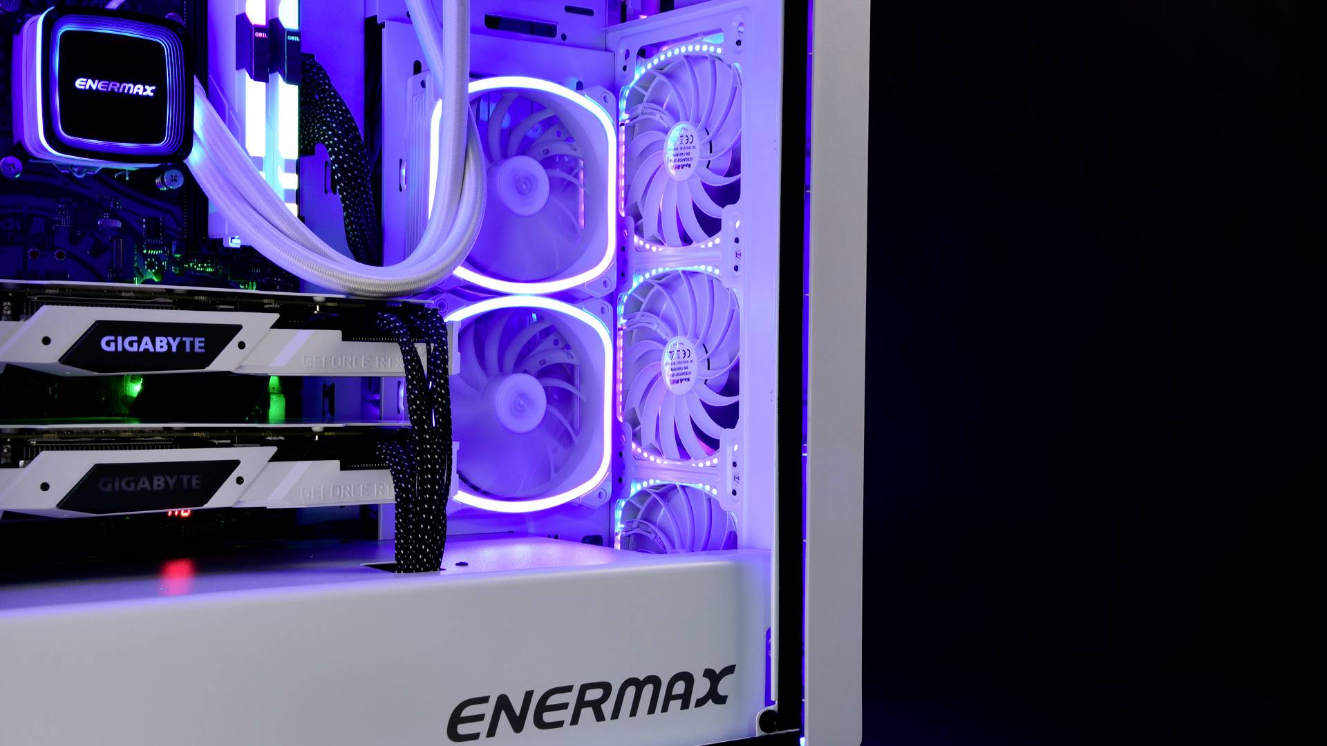 Ein Computergehäuse mit zwei Grafikkarten, beleuchtet durch leuchtende bunte LED-Lichter. Der Markenname 'ENERMAX' ist sichtbar.