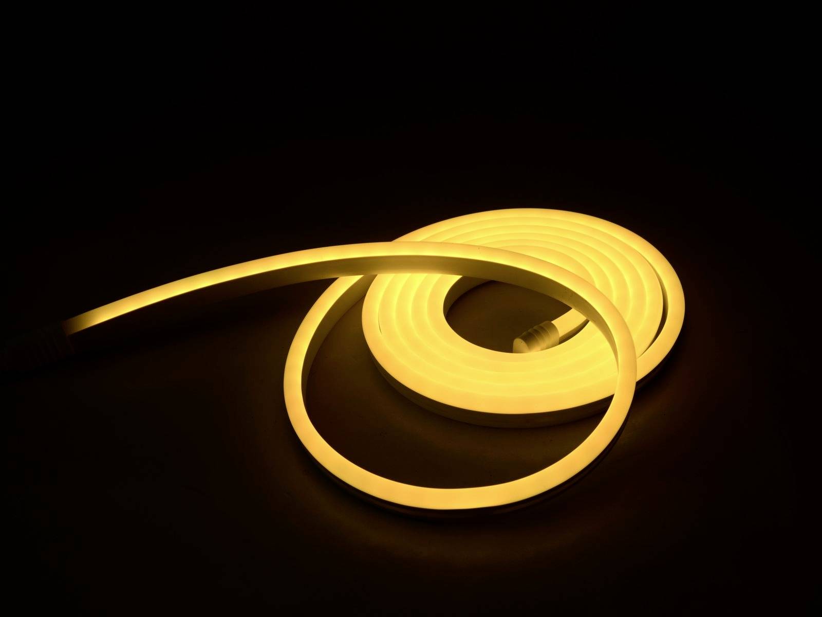 Ein gelbes LED-Lichtband leuchtet in einer spiralförmigen Anordnung auf einem dunklen Hintergrund.