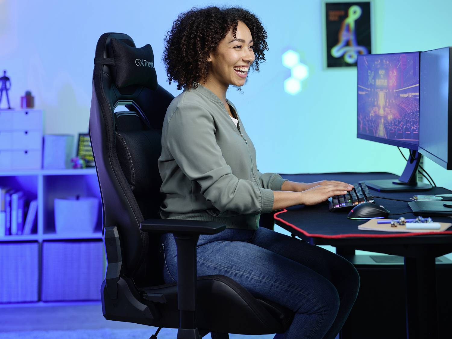 Person sitzt an einem Schreibtisch und arbeitet an einem Computer, wirkt konzentriert und zufrieden; im Hintergrund sind bunte Lichter.