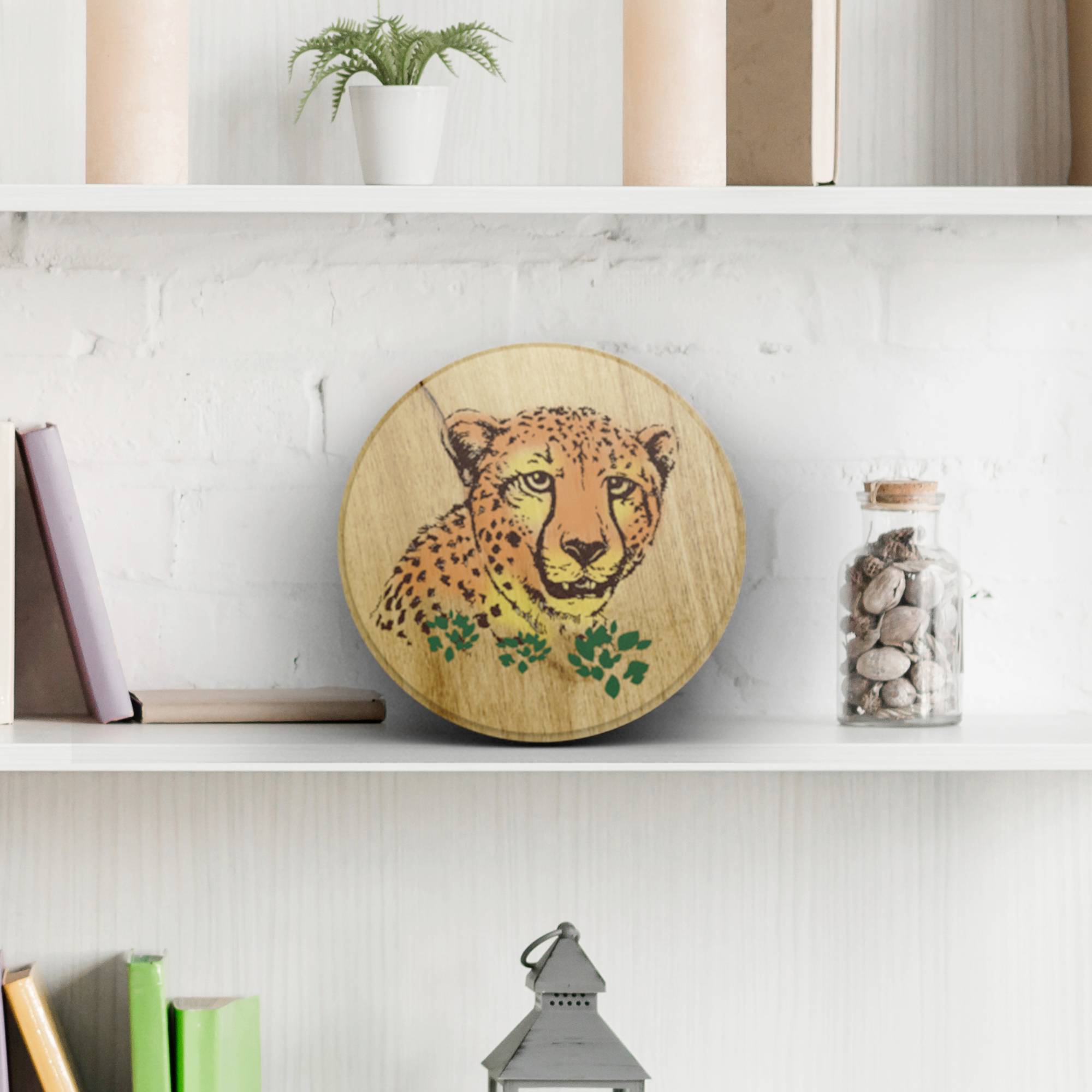 Runde Holzplatte mit Leopardenmotiv, auf Regal platziert. Dekorative Bücher und Pflanzen umgeben das Bild.