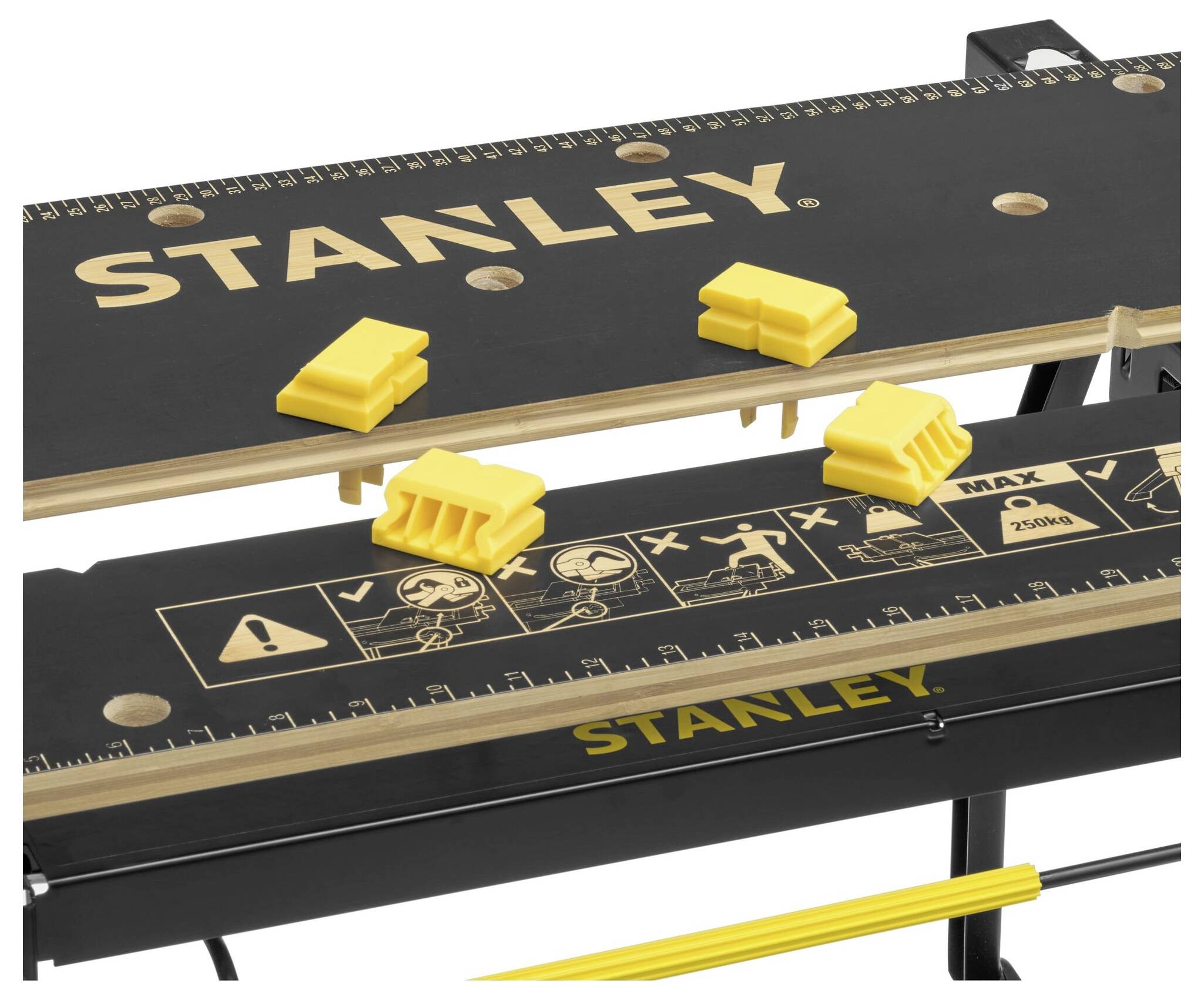 Kleiner, zusammenklappbarer Arbeitstisch von Stanley mit Linealmarkierungen und gelben Schraubzwingen, ideal für Heimwerkerarbeiten.