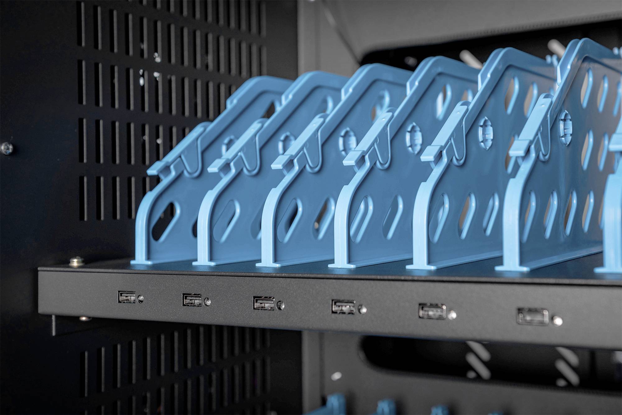 Blaue Metallhalterungen in einem schwarzen Gehäuse, das möglicherweise für Computer- oder Serverkomponenten verwendet wird.