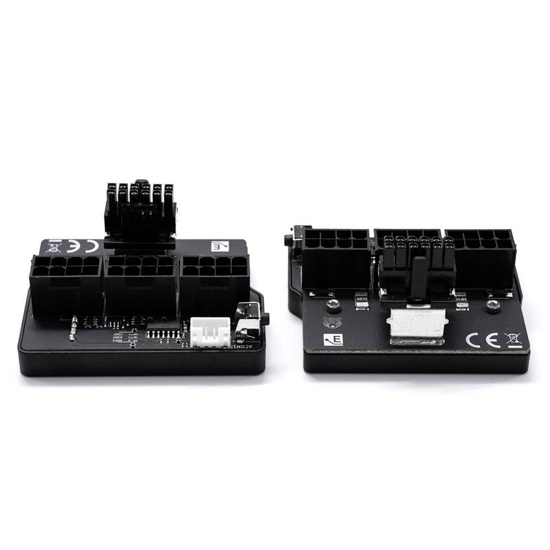 Zwei schwarze elektronische Adapter mit mehreren Anschlusssteckern und Beschriftungen, die auf einer weißen Fläche liegen.