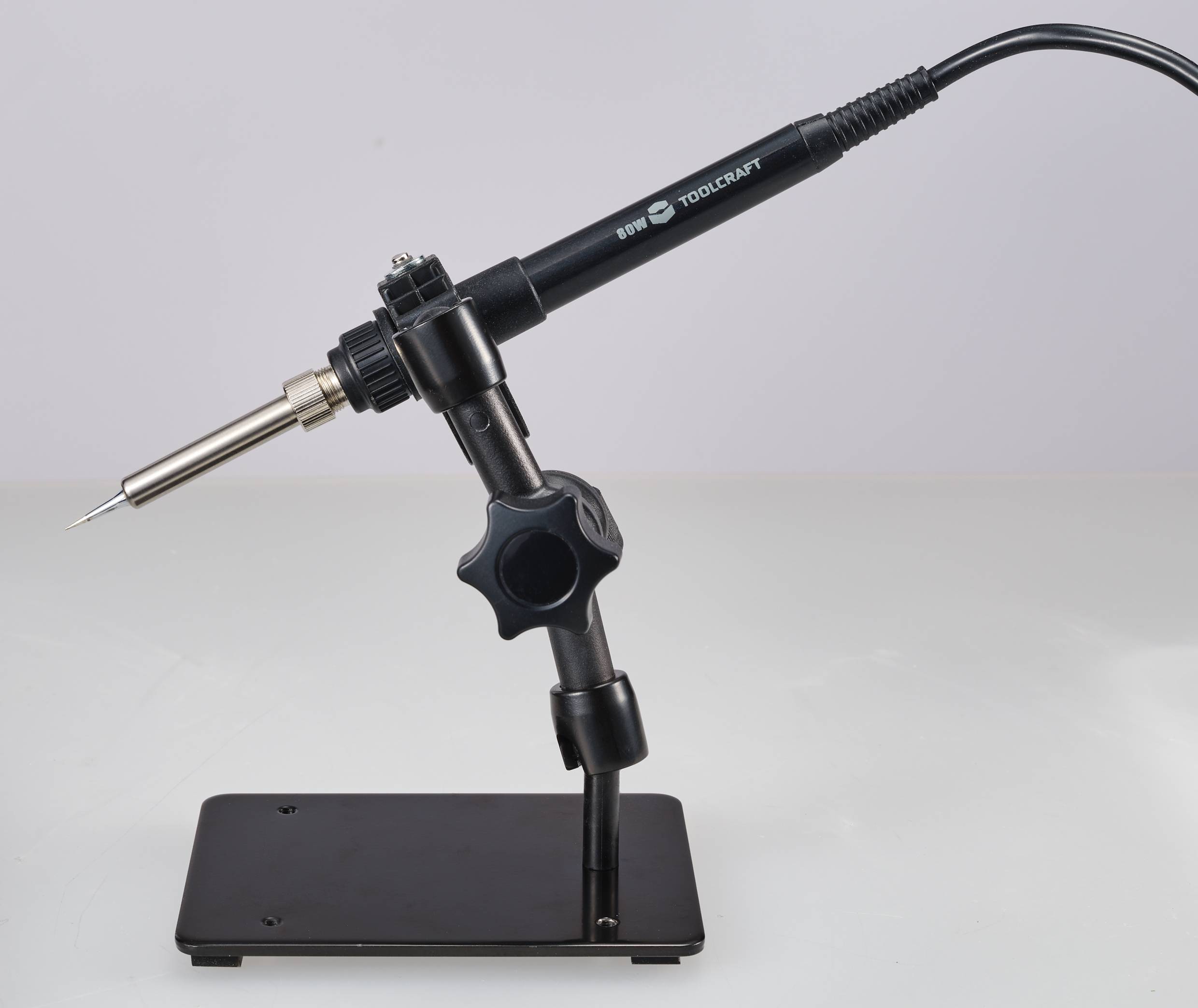 Ein schwarzer Lötkolben in einer Halterung auf einem Tisch, bereit zum Einsatz.
