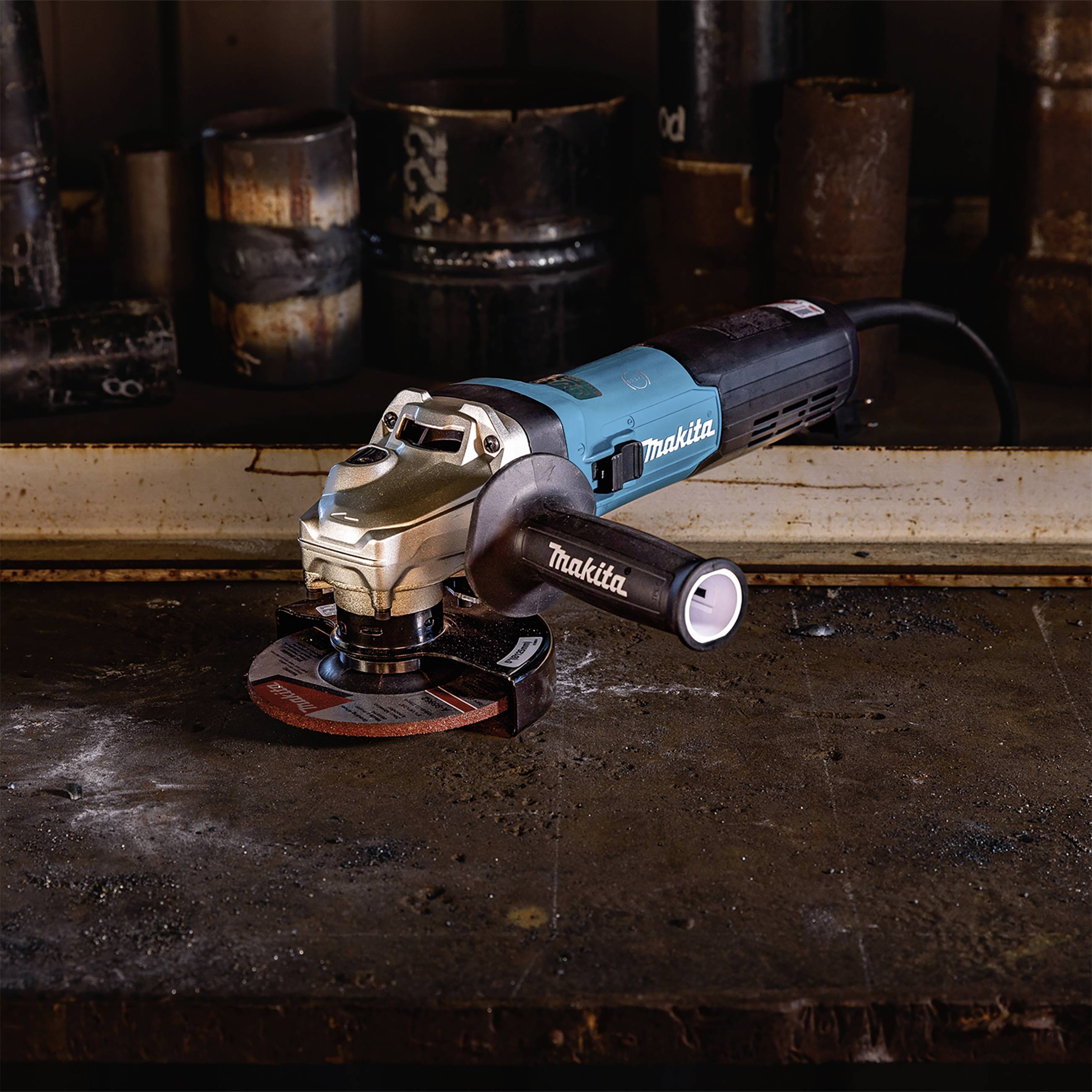 Ein Winkelschleifer liegt auf einer Werkbank, umgeben von Metallteilen. Hauptsächlich blau, mit einem schwarzen Griff und roter Schleifscheibe.