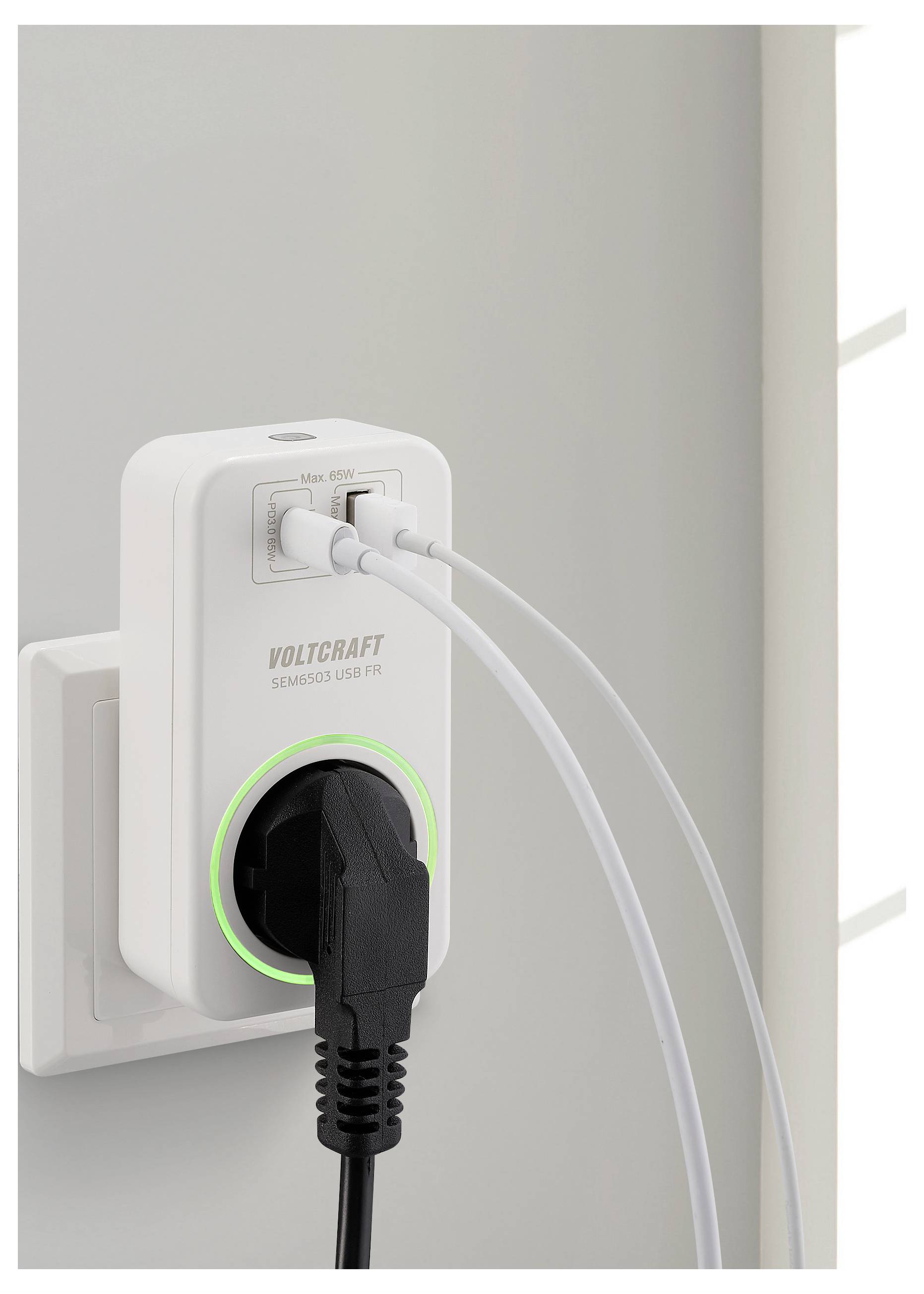 Ein Stromadapter mit digitalem Display ist in eine Wandsteckdose eingesteckt. Er hat zwei angeschlossene USB-Kabel und ein Stromkabel, wobei ein grünes Licht anzeigt, dass er eingeschaltet ist.