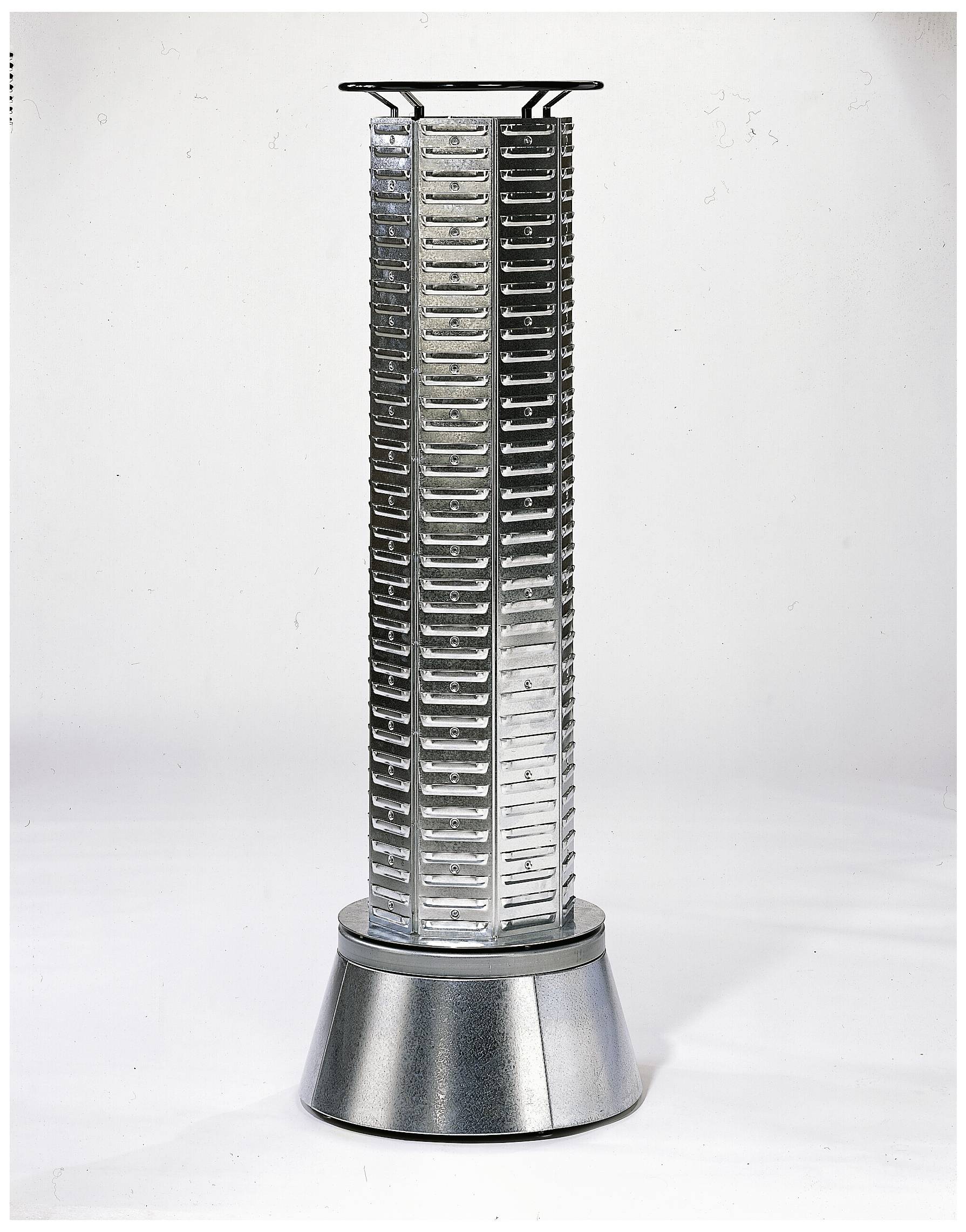 Ein silberner, zylindrischer Turm mit mehreren Schlitzen auf einem metallischen, konischen Sockel. Wissenschaftlich-technisches Design.