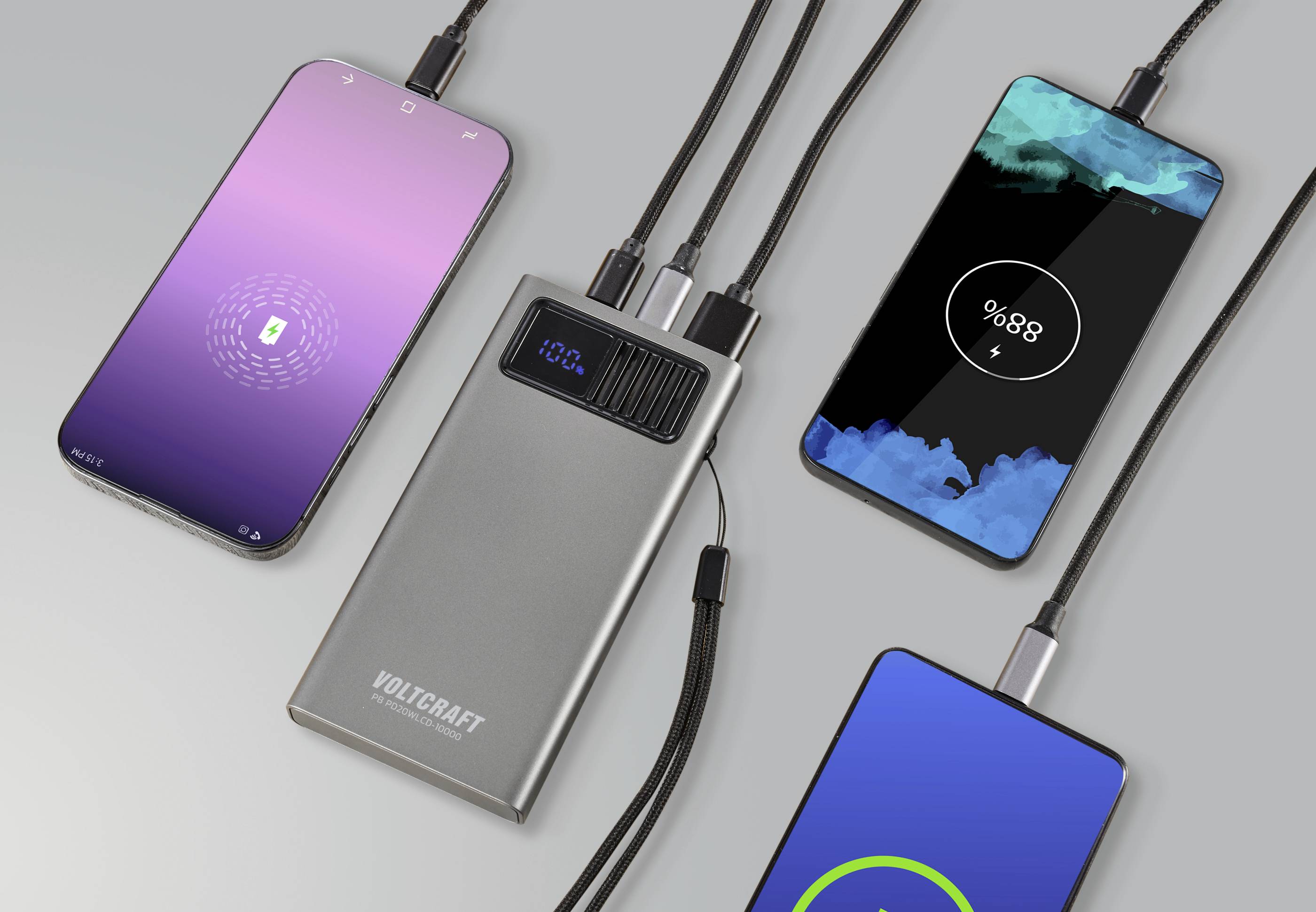 Drei Smartphones mit einem Ladegerät verbunden, das den Ladezustand anzeigt. Zwei Bildschirme zeigen Ladeanimationen.