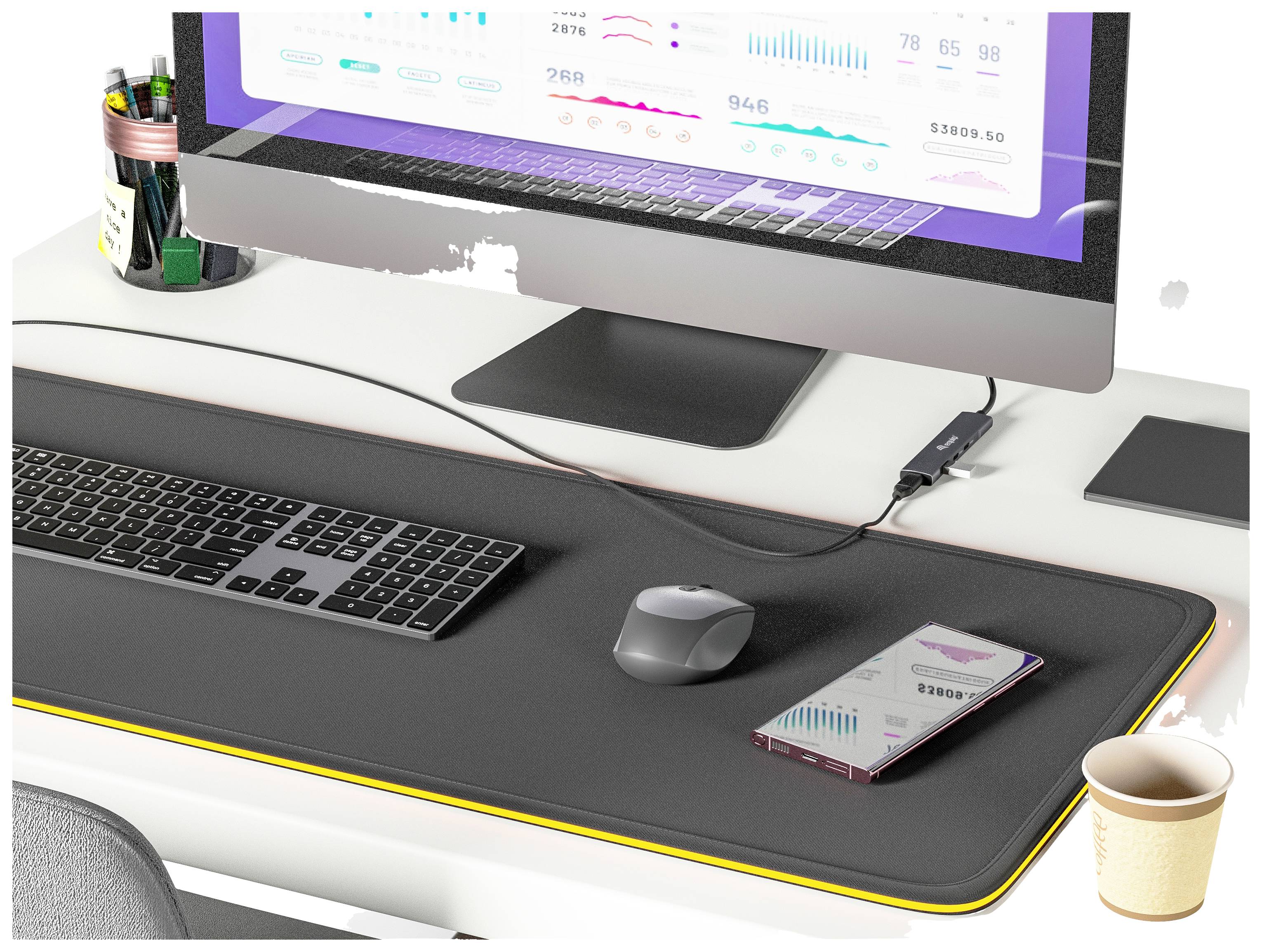 Ein moderner Schreibtisch mit einem großen Monitor, Tastatur, Maus, Smartphone und einer Tasse Kaffee. Der Bildschirm zeigt grafische Daten.