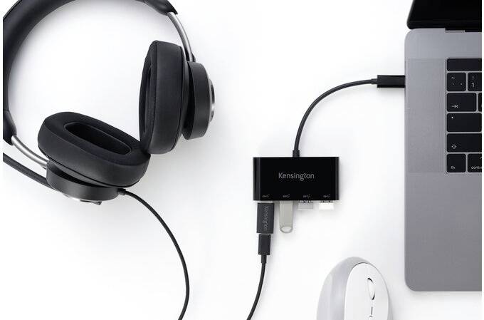 Ein schwarzes Headset, ein USB-Hub und eine Maus sind an einen Laptop angeschlossen.