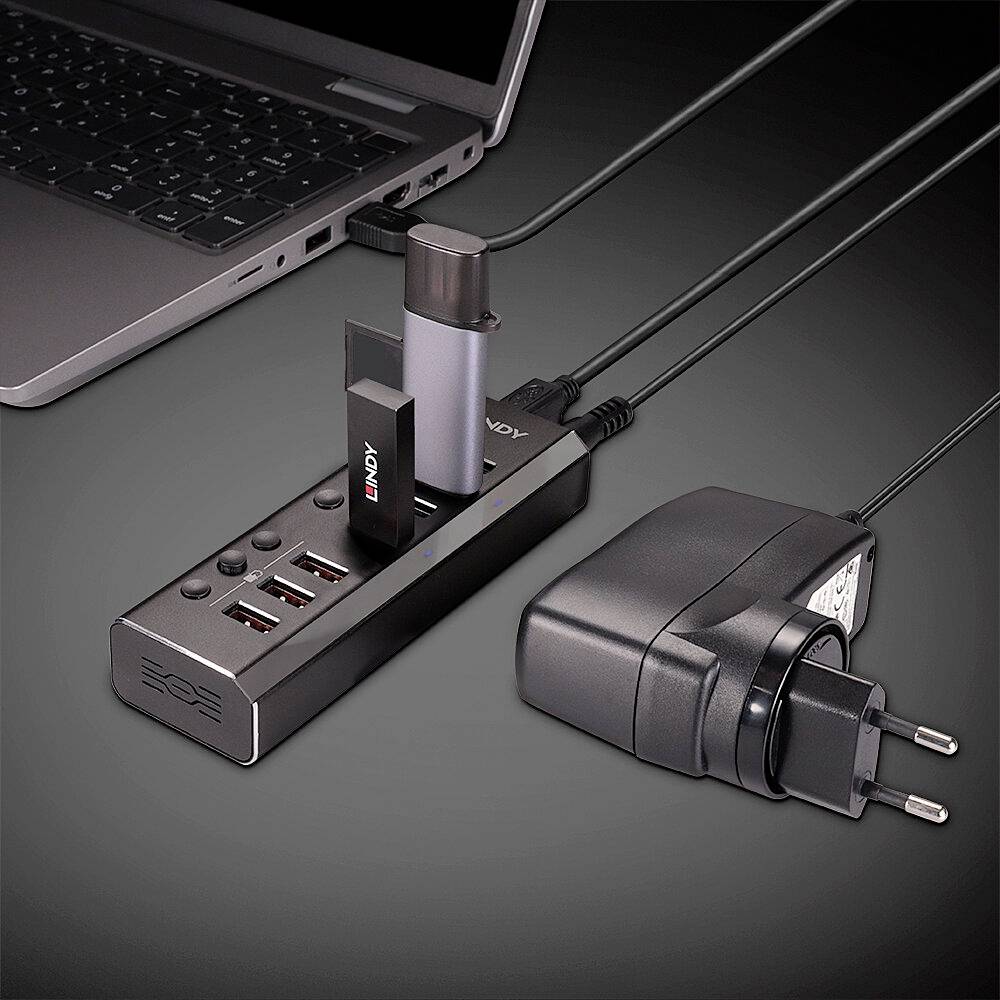 Ein Laptop ist über mehrere Kabel und Adapter mit einer Dockingstation verbunden. Die Dockingstation hat mehrere USB-Anschlüsse.