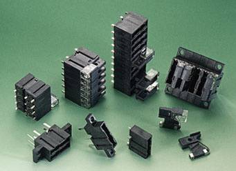 Mehrere schwarze elektronische Steckverbinder unterschiedlicher Größe und Form sind auf einem grünen Hintergrund angeordnet.