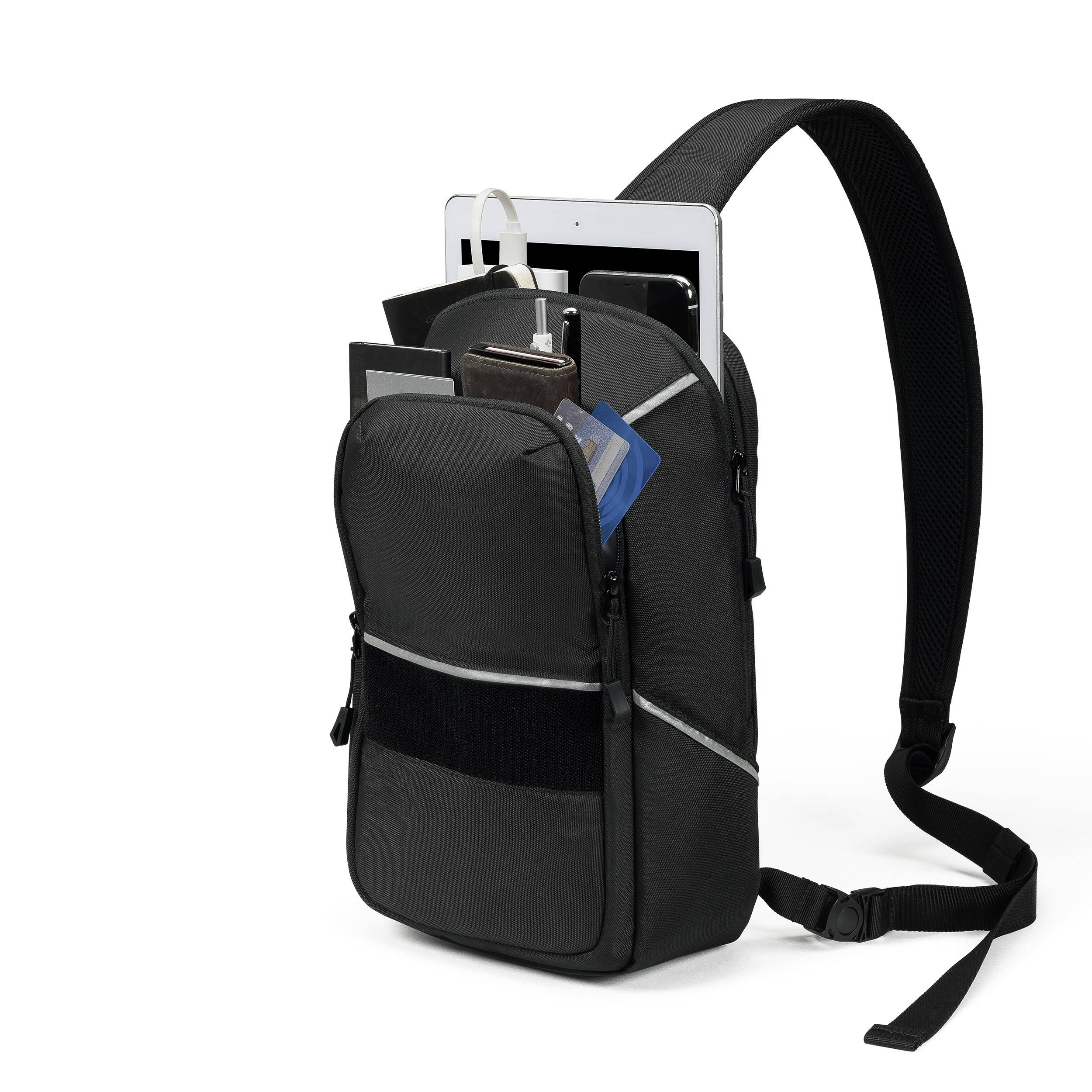 Ein schwarzer Rucksack ist geöffnet und zeigt eine Tablet, ein Notizbuch, zwei Stifte und ein Mobiltelefon. Der Schultergurt ist sichtbar.