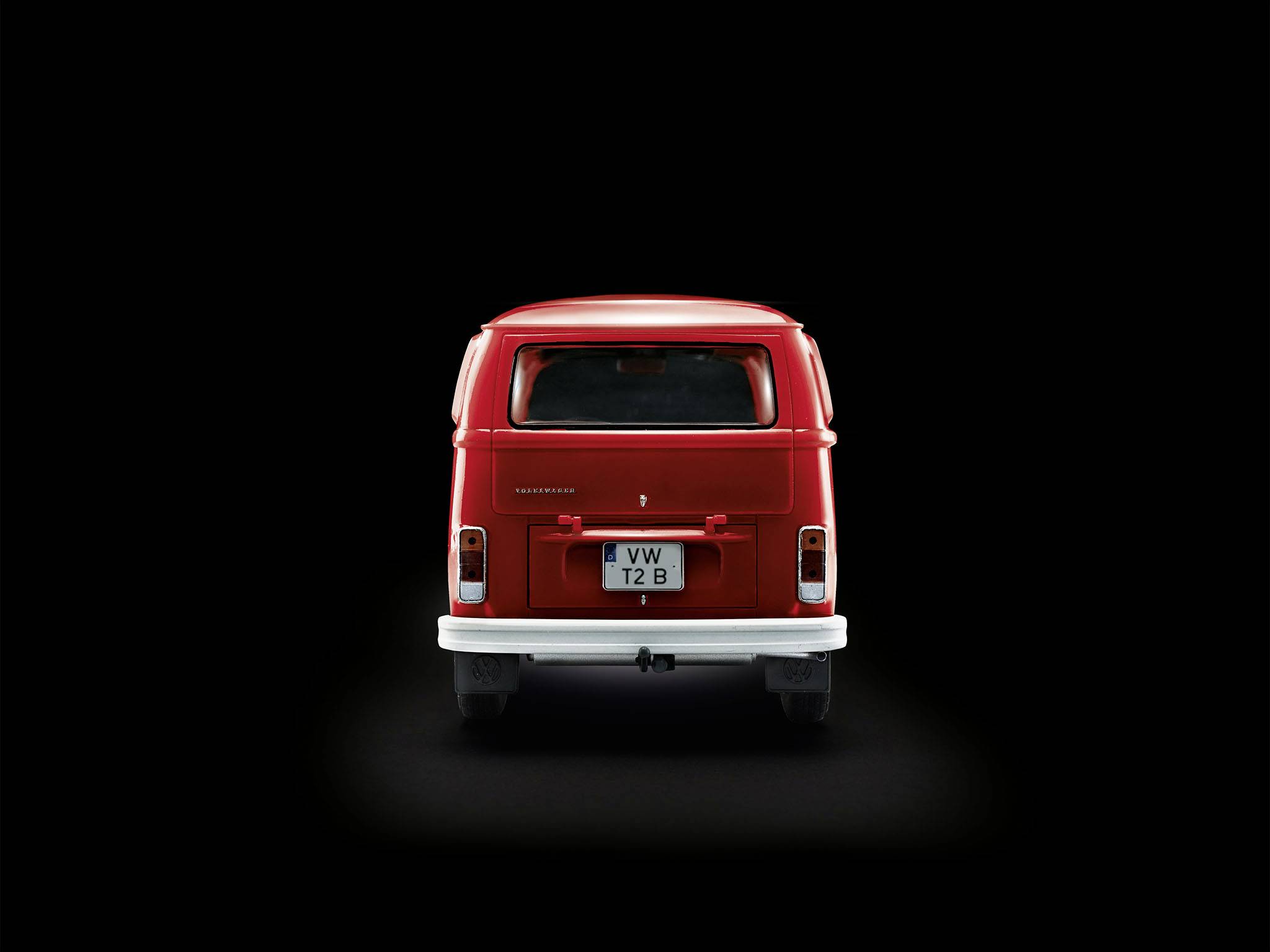 Roter VW Bus von hinten, im Vordergrund auf dunklem Hintergrund.