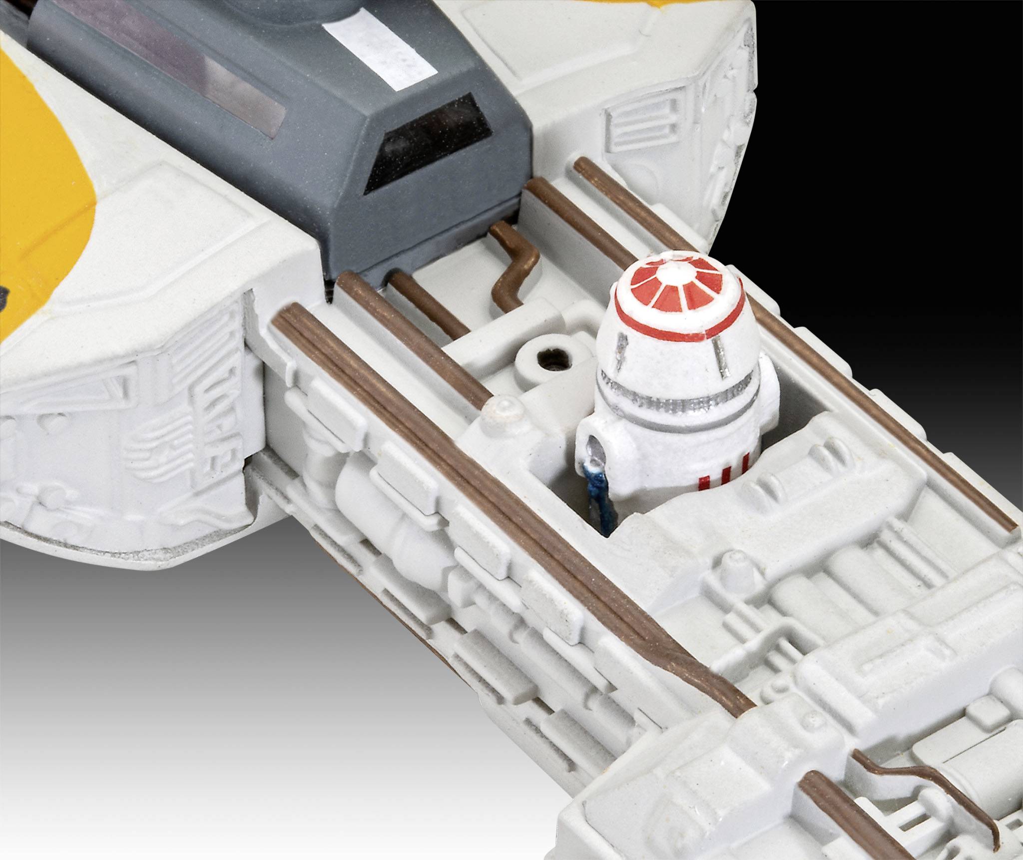 Ein Modell eines Raumschiffs mit orangefarbenen Akzenten. Im Cockpit sitzt ein kleiner Roboter. Der Hintergrund ist schwarz-weiß verlaufend.