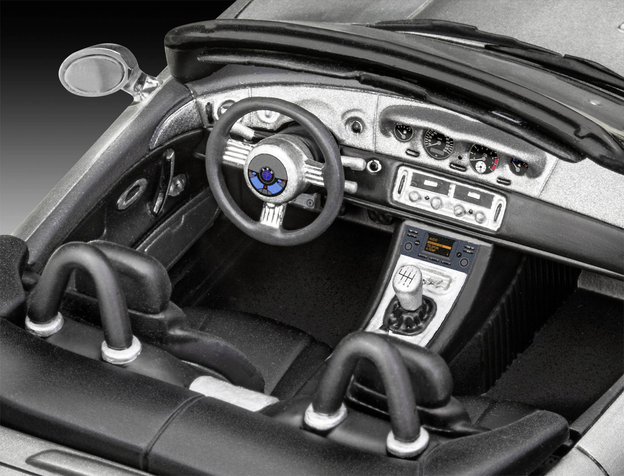 Zwei Sitze eines Sportwagen-Cockpits mit Lenkrad, Armaturenbrett und Mittelkonsole in Schwarz und Silber, bereit zum Fahren.