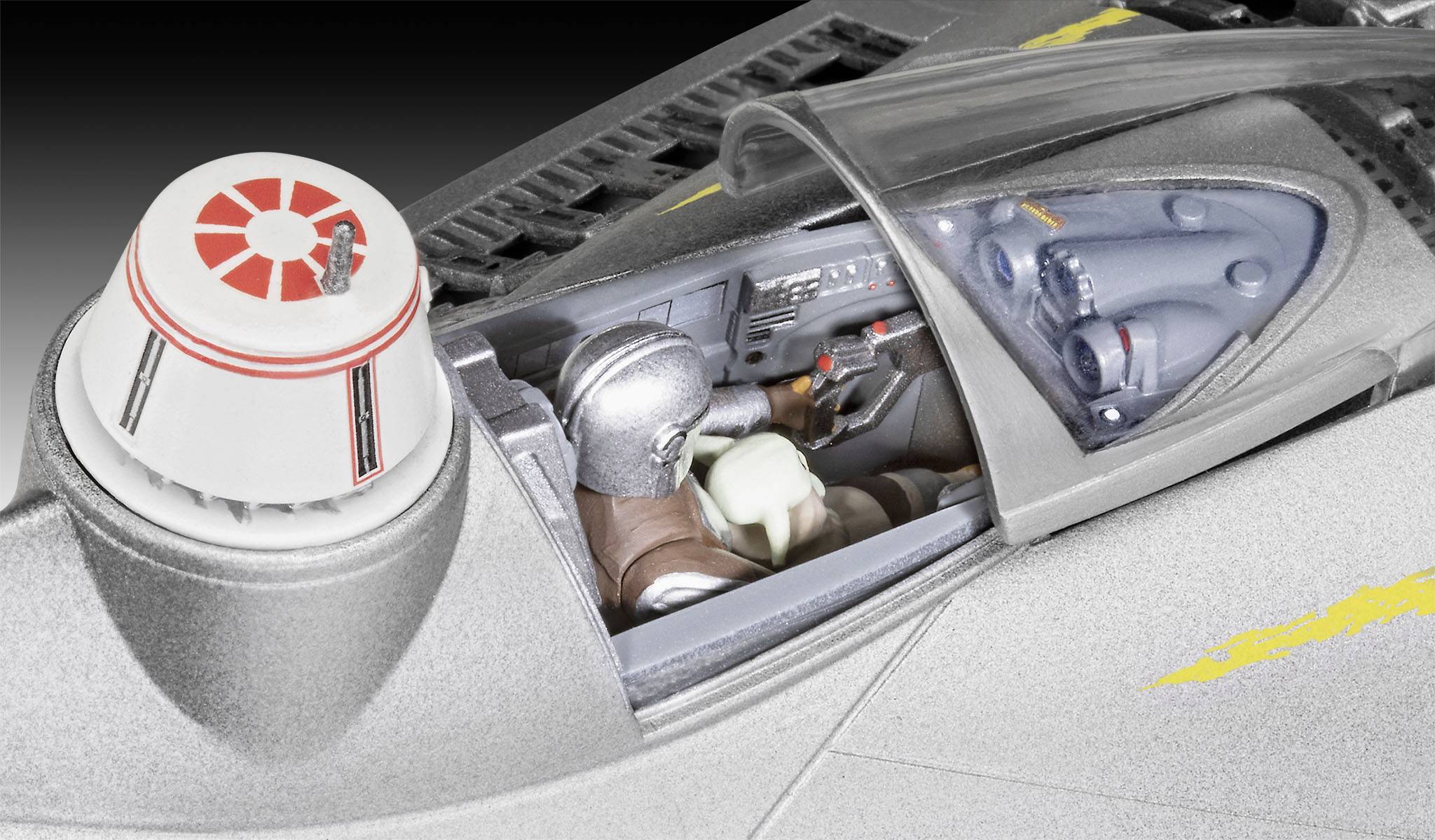 Ein silbernes Raumschiff-Modell mit einem durchsichtigem Cockpit. Drinnen sind zwei Figuren in Raumanzügen zu sehen.