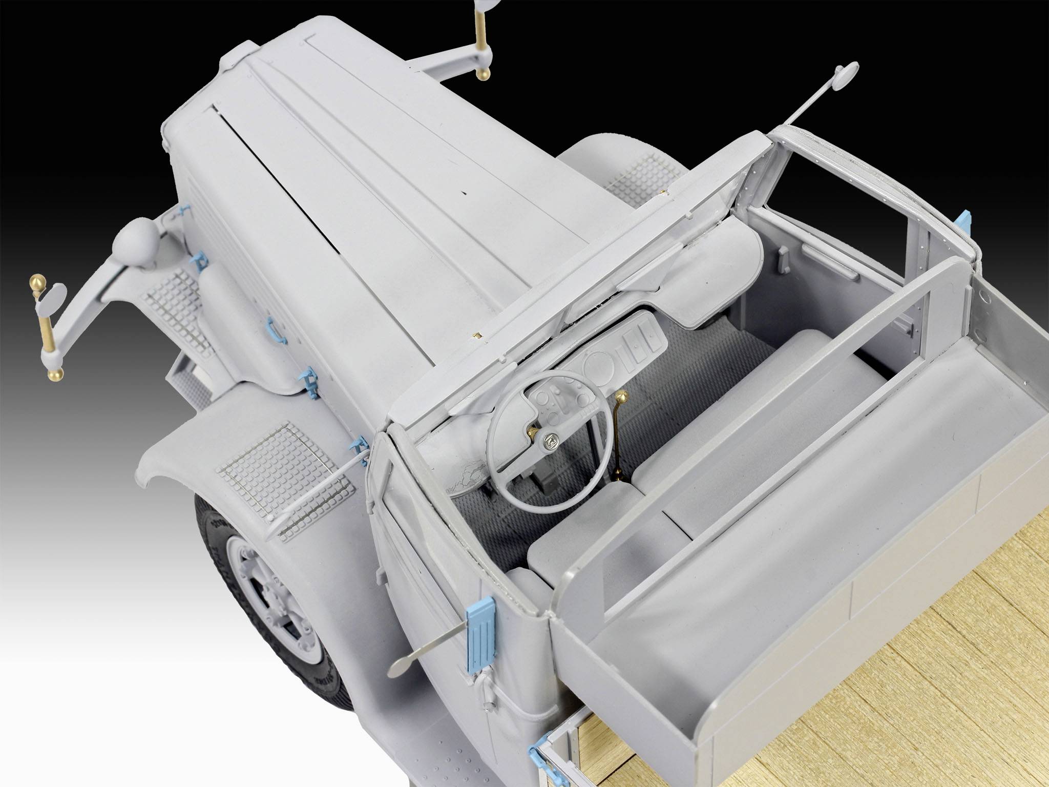 Ein Modell eines historischen Militärfahrzeugs von oben. Das Fahrzeug ist größtenteils grau mit blauen Akzenten und einem offenen Ladebereich.