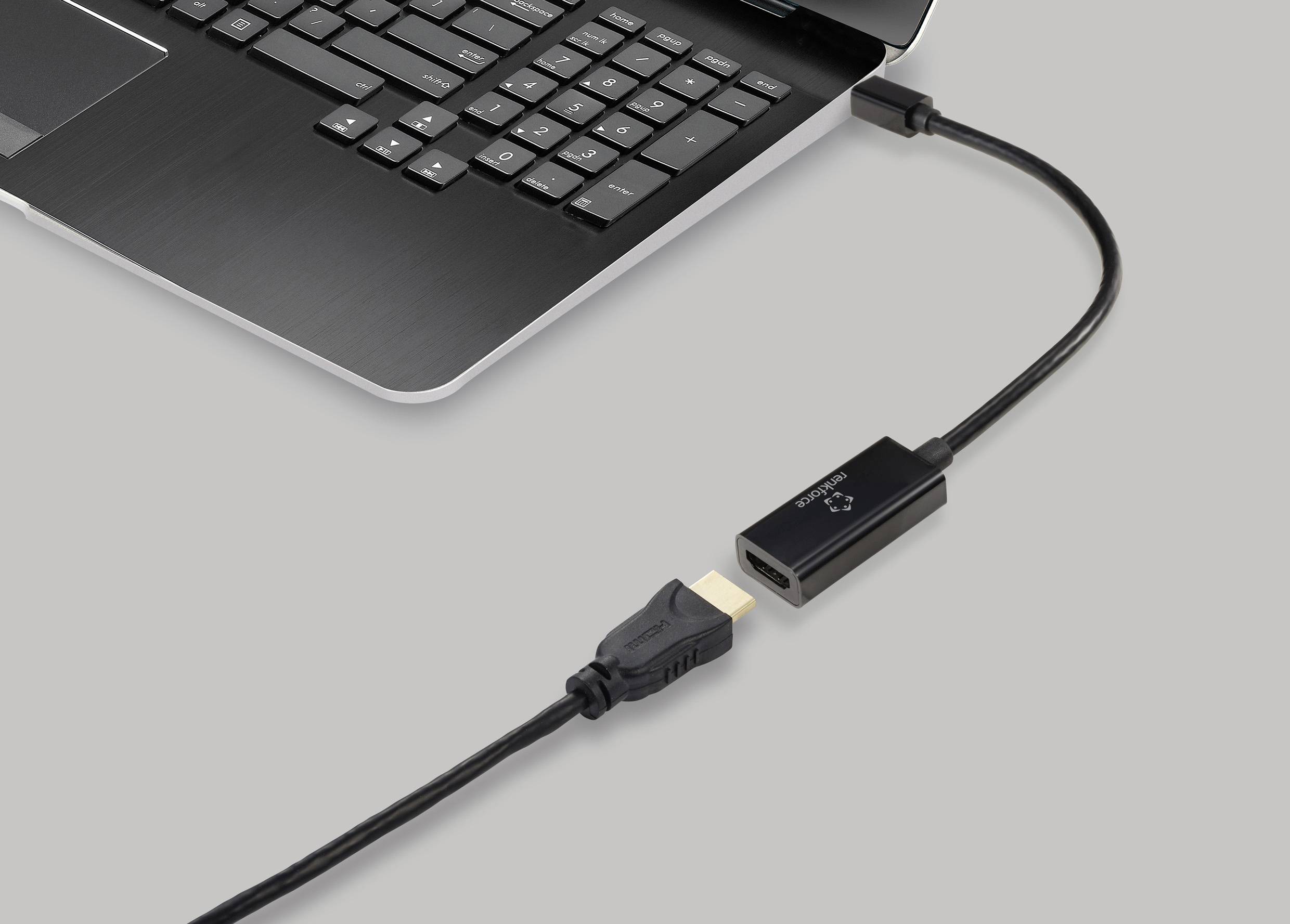 Ein Laptop mit einem angesteckten HDMI-Kabel an einen Adapter, der einen anderen Anschluss bereitstellt.