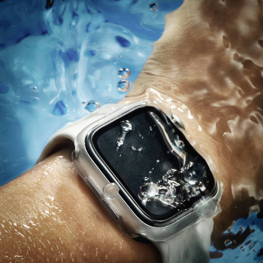 Uhr am Handgelenk unter Wasser, zeigt Robustheit und Wasserdichtigkeit. Hintergrund blau mit spritzendem Wasser.