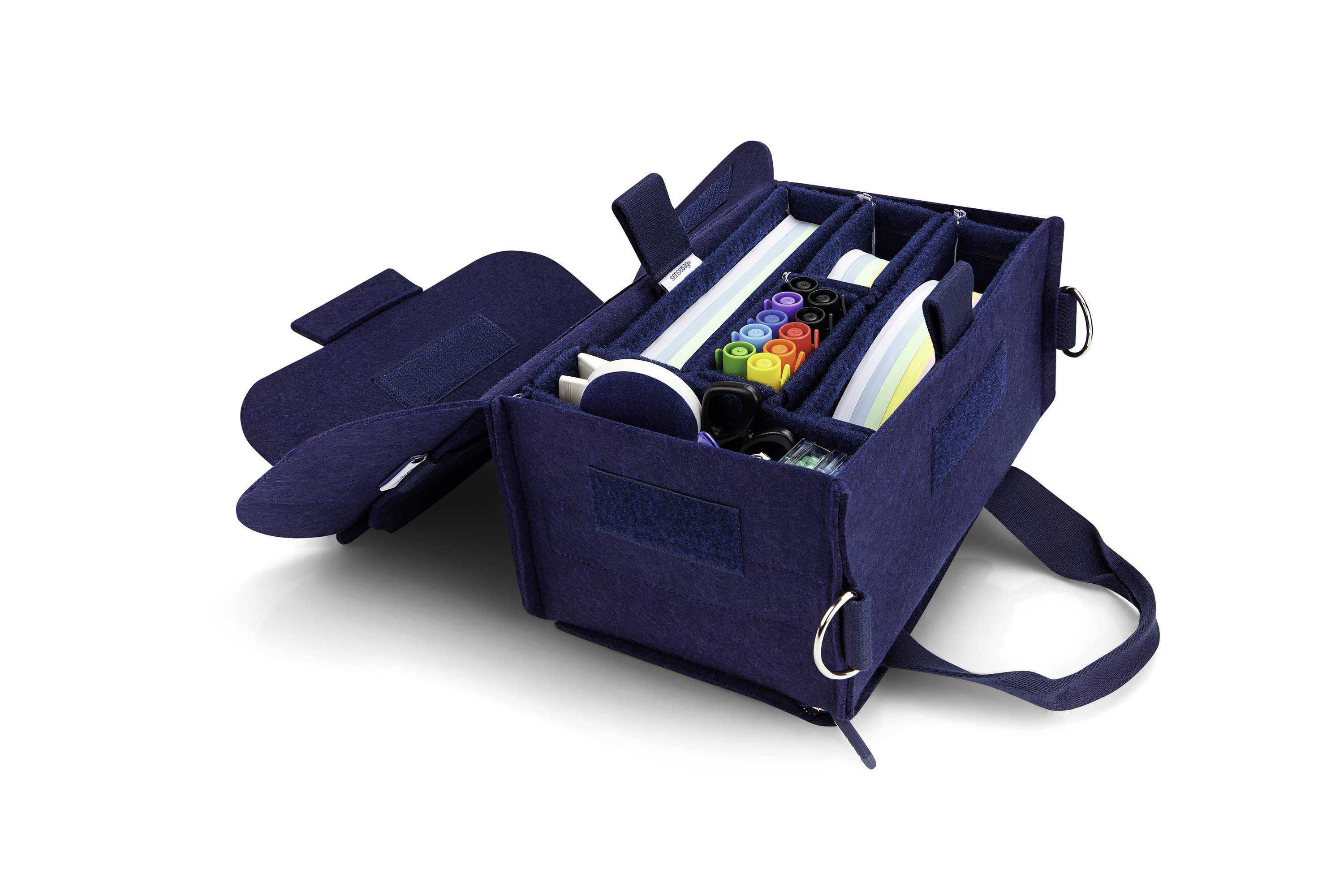Geöffnete blaue Filztasche mit mehreren Fächern, gefüllt mit Buntstiften, einem Notizbuch und Büroklammern, auf weißem Hintergrund.