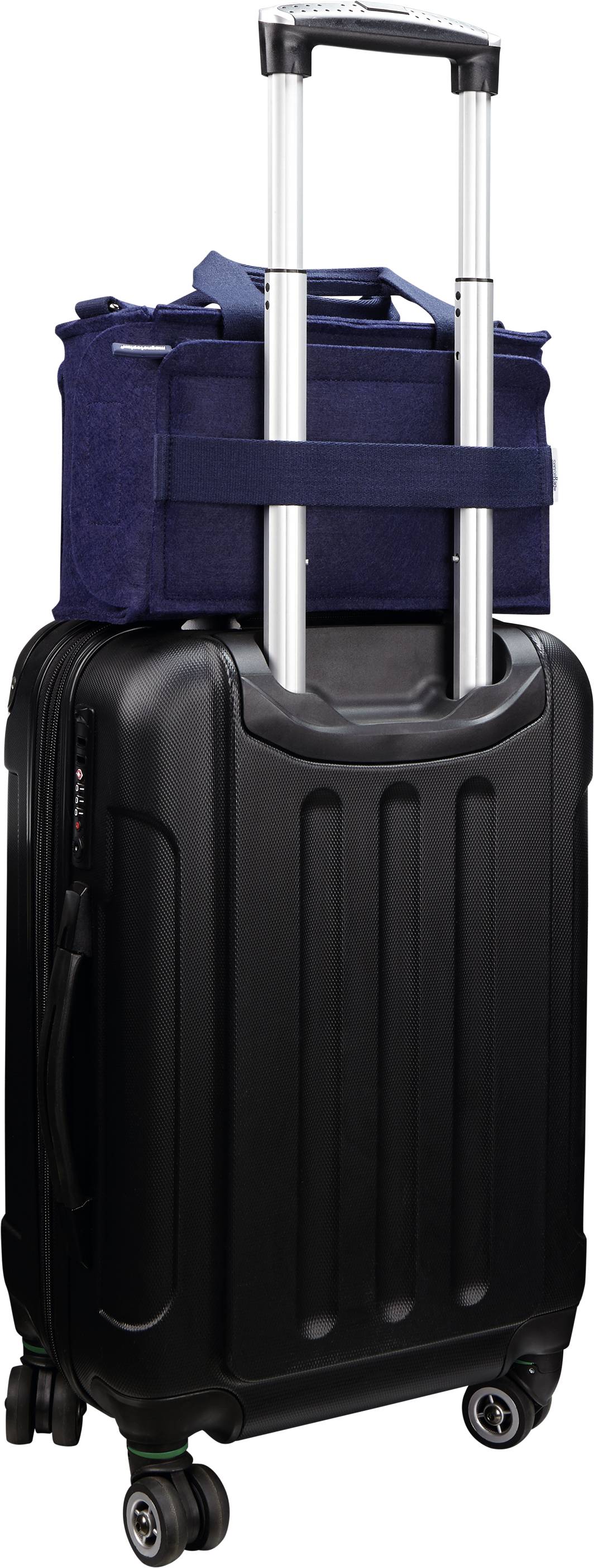 Ein schwarzer Rollkoffer mit Teleskopgriff. Oben auf dem Koffer sitzt eine blaue Tasche. Beide sind reisefertig gepackt.