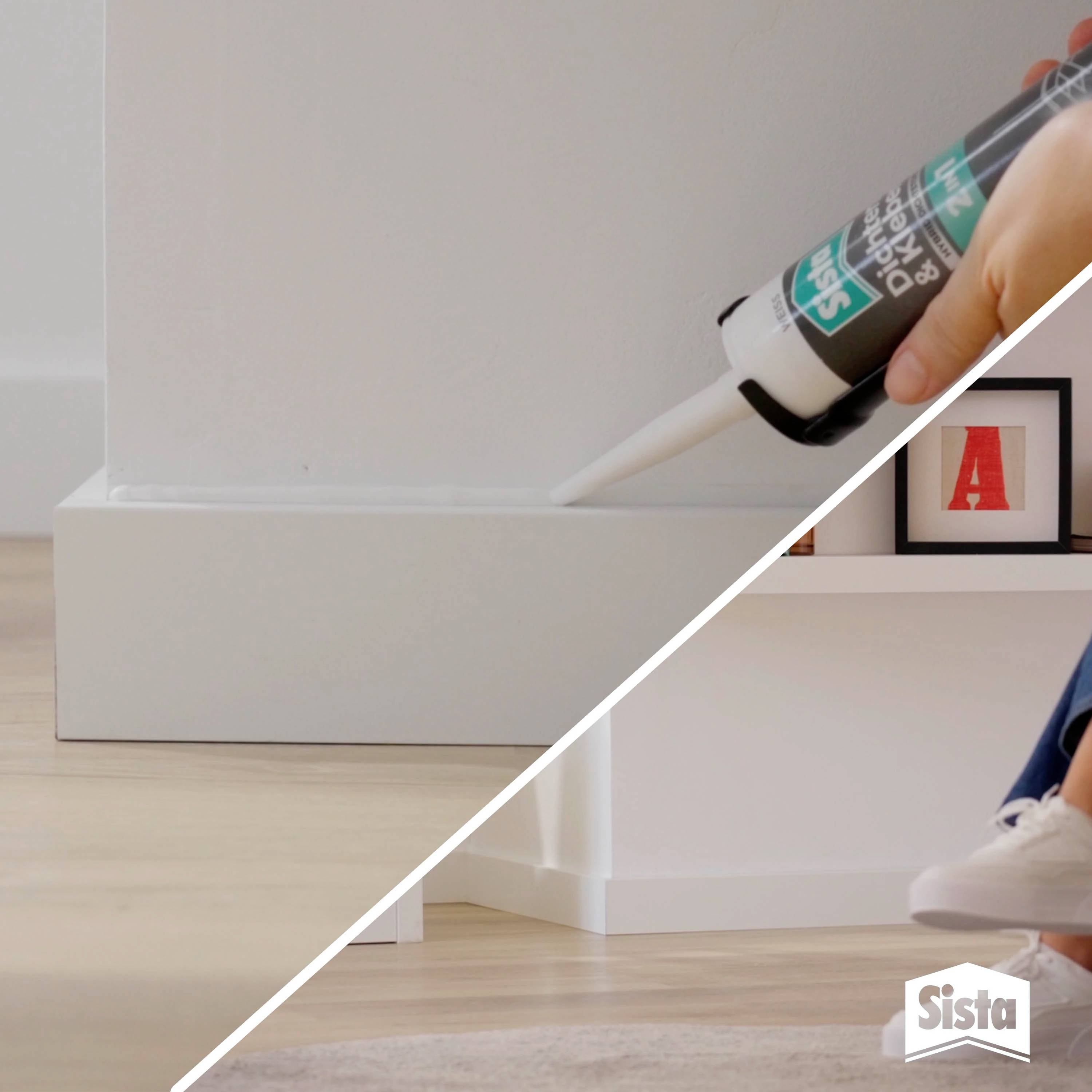 Eine Person appliziert mit einer Kartuschenpistole Dichtmasse entlang einer Fußleiste. Der obere Rand ist bereits versiegelt.