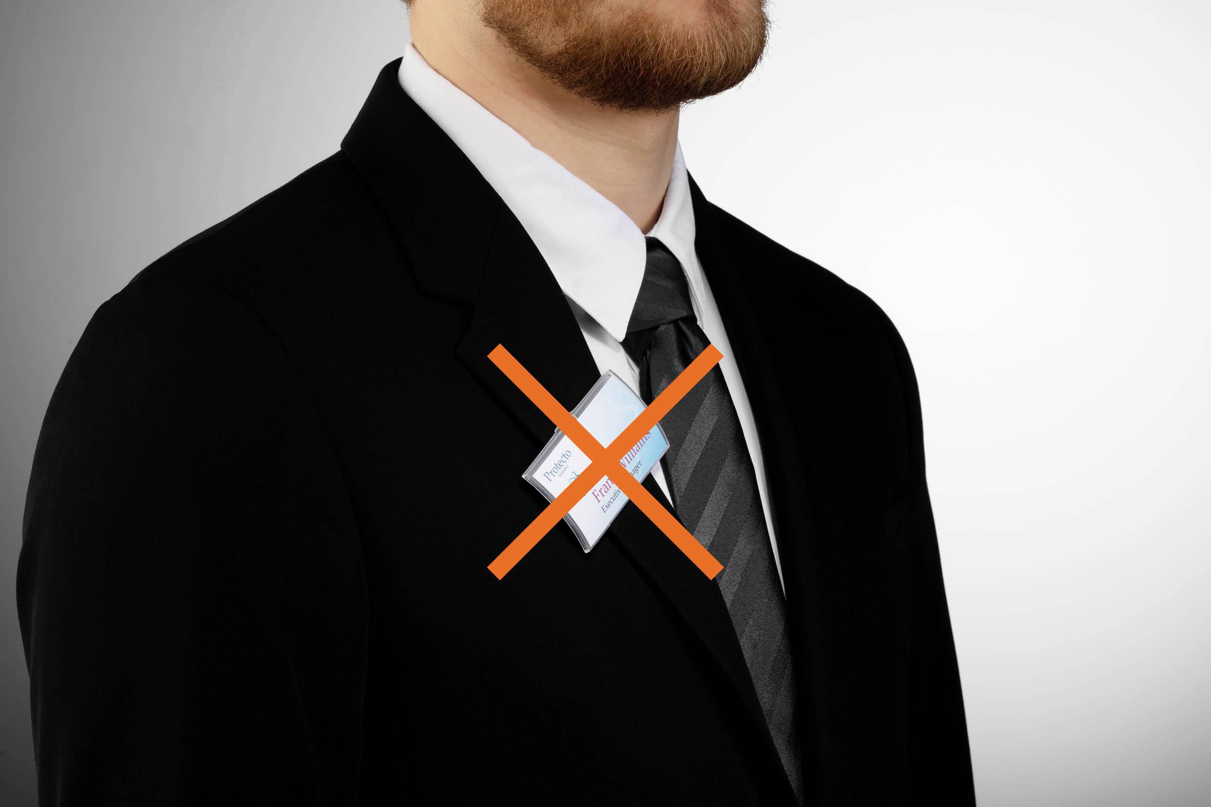 Ein Mann im Anzug trägt ein Namensschild mit einem roten Kreuz darauf, symbolisierend, dass es unerwünscht oder verboten ist.