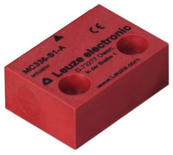 Rotes rechteckiges Elektronik-Bauteil mit zwei Vertiefungen, Aufschrift 'Leuze electronic'. CE-Zeichen und Modellnummer 'MC338-S1-A'.