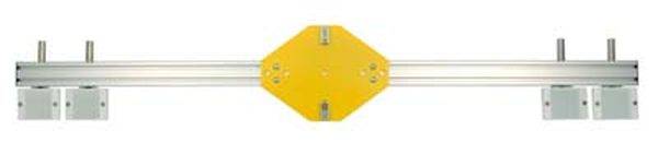 Ein gelber Metallverbinder ist an einer horizontalen Aluminiumschiene befestigt, mit Klemmhalterungen an beiden Enden der Schiene.