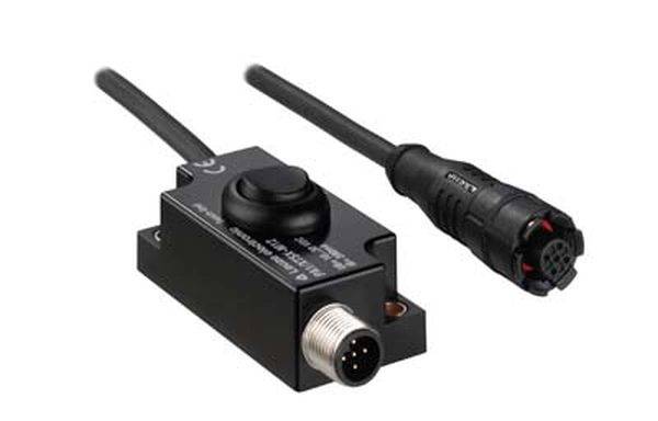 Schwarzer rechteckiger Sensor mit zwei Kabeln, einem Stecker und einer Buchse. Verwendet für elektronische Verbindungen und Steuerungen.