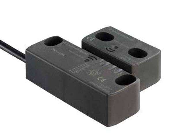 Ein schwarzer, rechteckiger Sensor mit Kabel, bestehend aus zwei Teilen. Er hat Symbole und Aufschriften mit technischen Informationen.