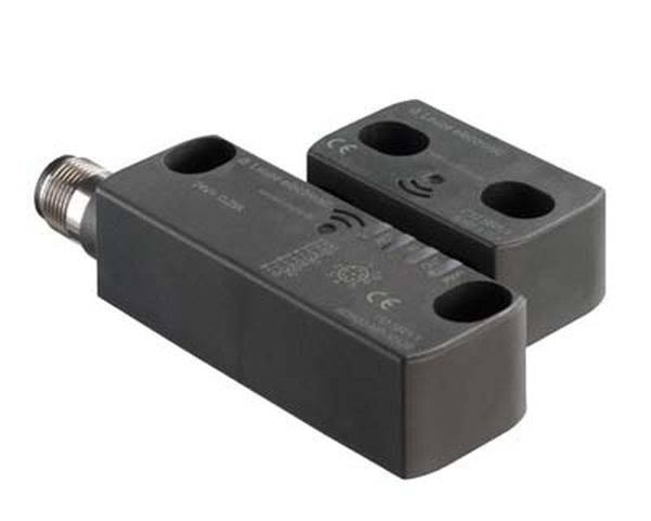 Ein rechteckiger Sensor mit zwei Bohrungen und einem Metallanschluss. Auf dem Sensor sind Symbole für CE-Kennzeichnung zu sehen.