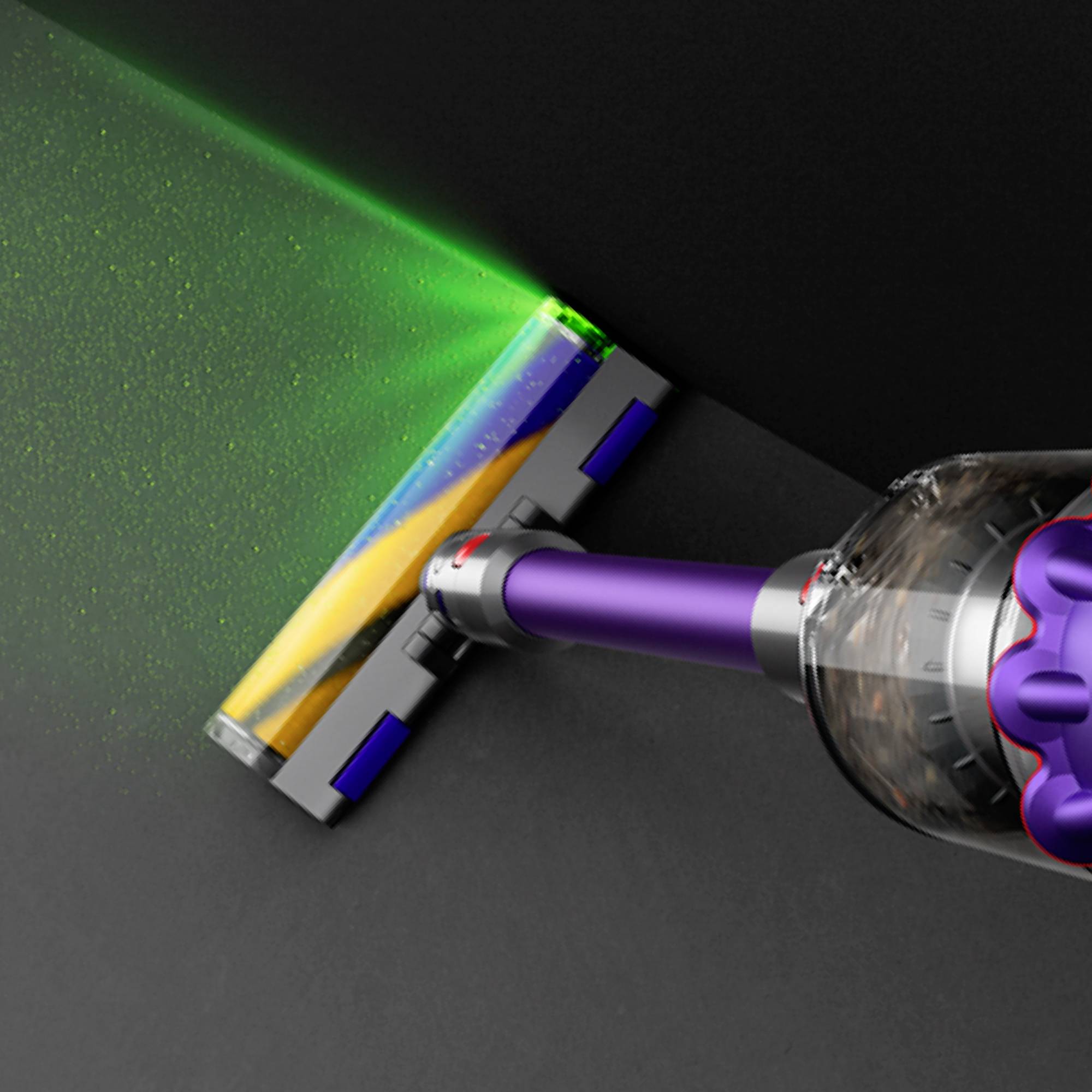 Ein Staubsauger mit lila Griff saugt Staub von einem dunklen Boden ab. Ein grünes Licht hebt Schmutzpartikel hervor.