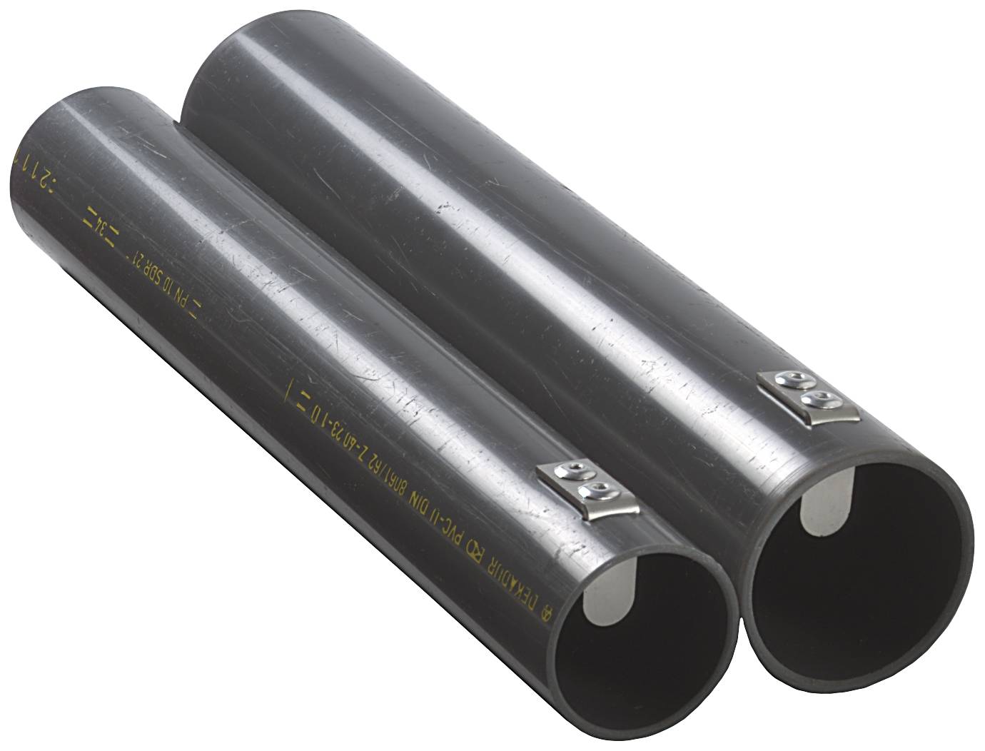 Zwei schwarze Kunststoffrohre, nebeneinander liegend, mit metallischen Beschriftungsschildern an jedem Rohr.
