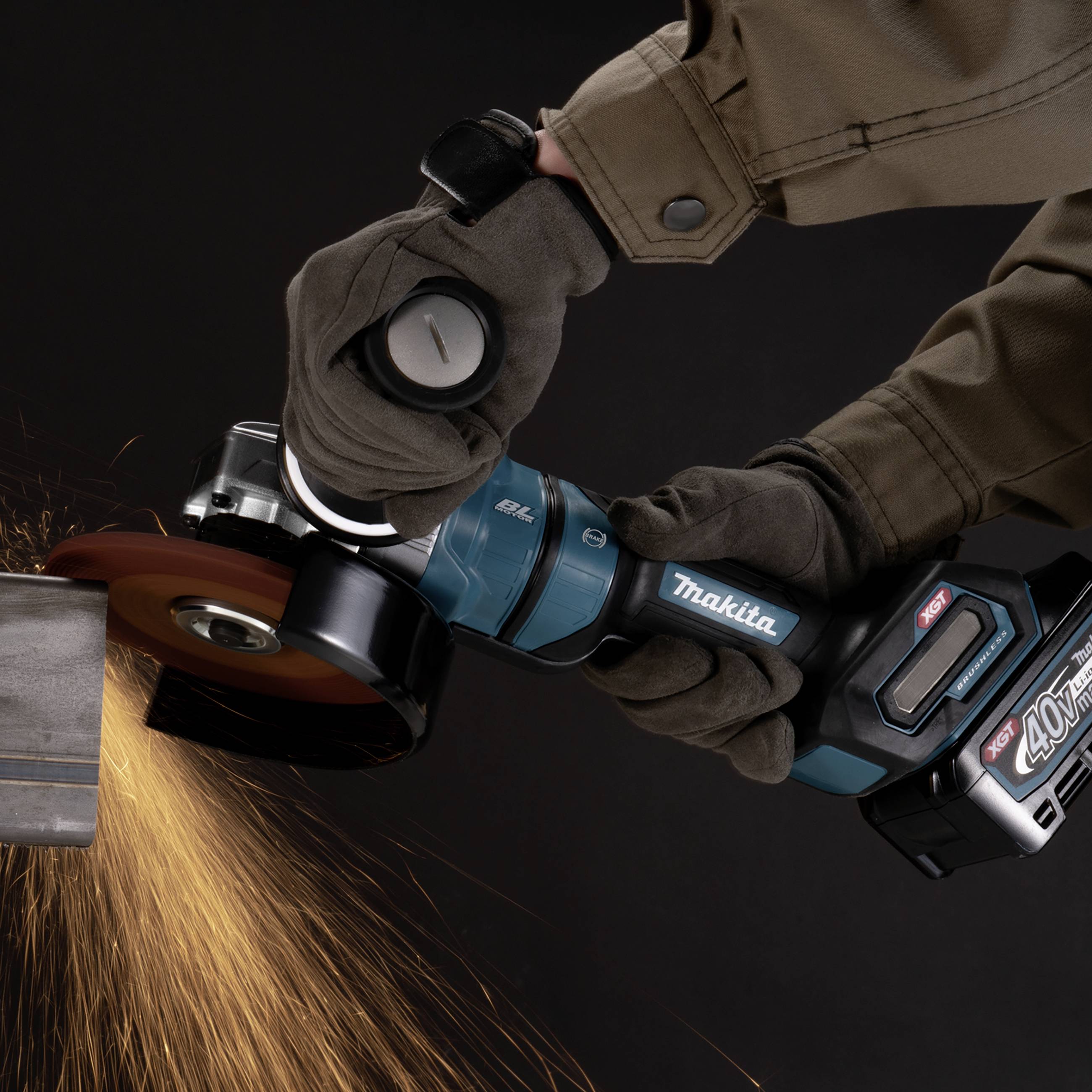 Eine Person schleift mit einem Winkelschleifer Metall, Funken sprühen. Sie trägt Schutzkleidung, einschließlich Handschuhe.