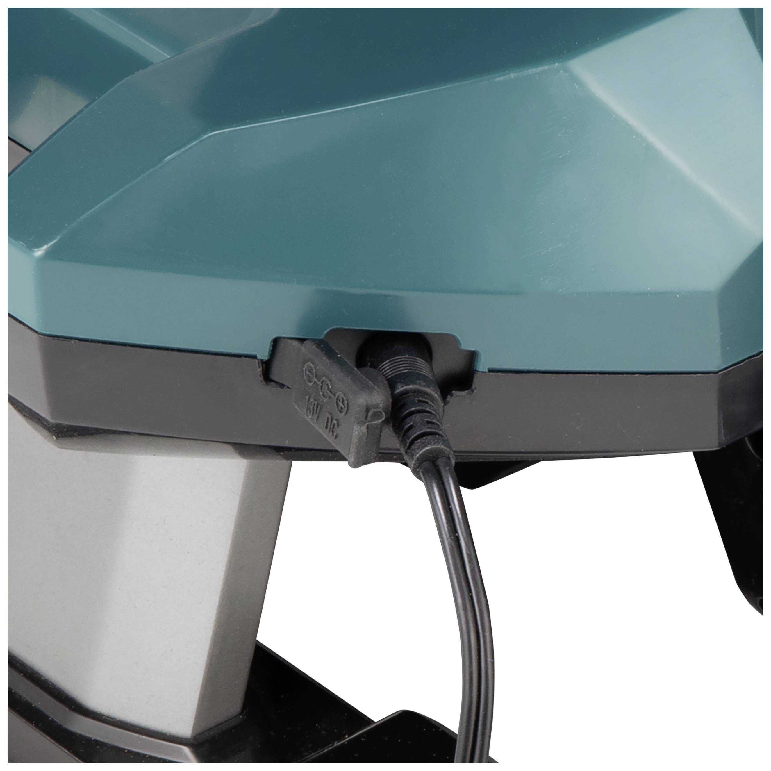 Türkises elektrisches Gerät mit eingestecktem Ladekabel. Oben geometrisch geformte Oberfläche. Gerät könnte für industrielle Nutzung sein.