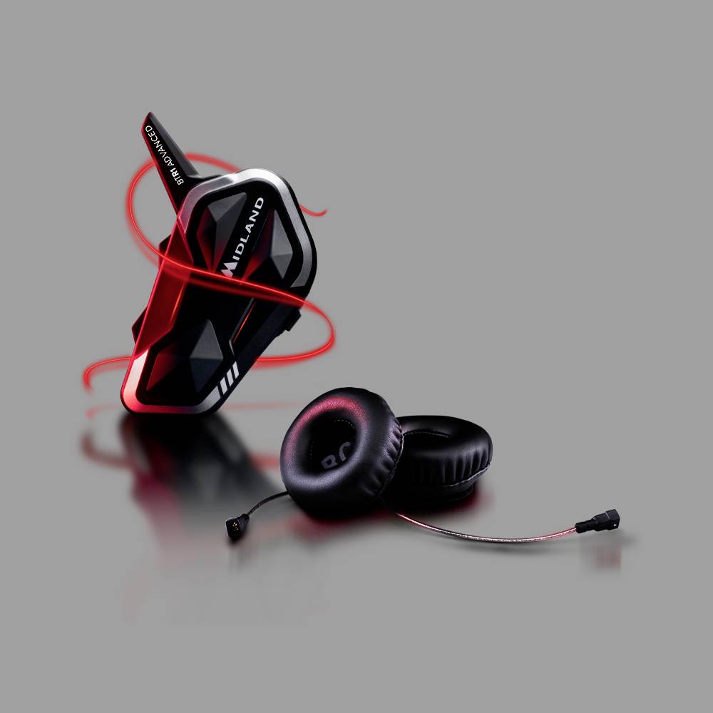 'Ein schwarzes Motorrad-Kommunikationsgerät mit roter Beleuchtung, daneben schwarze Kopfhörer mit rotem 