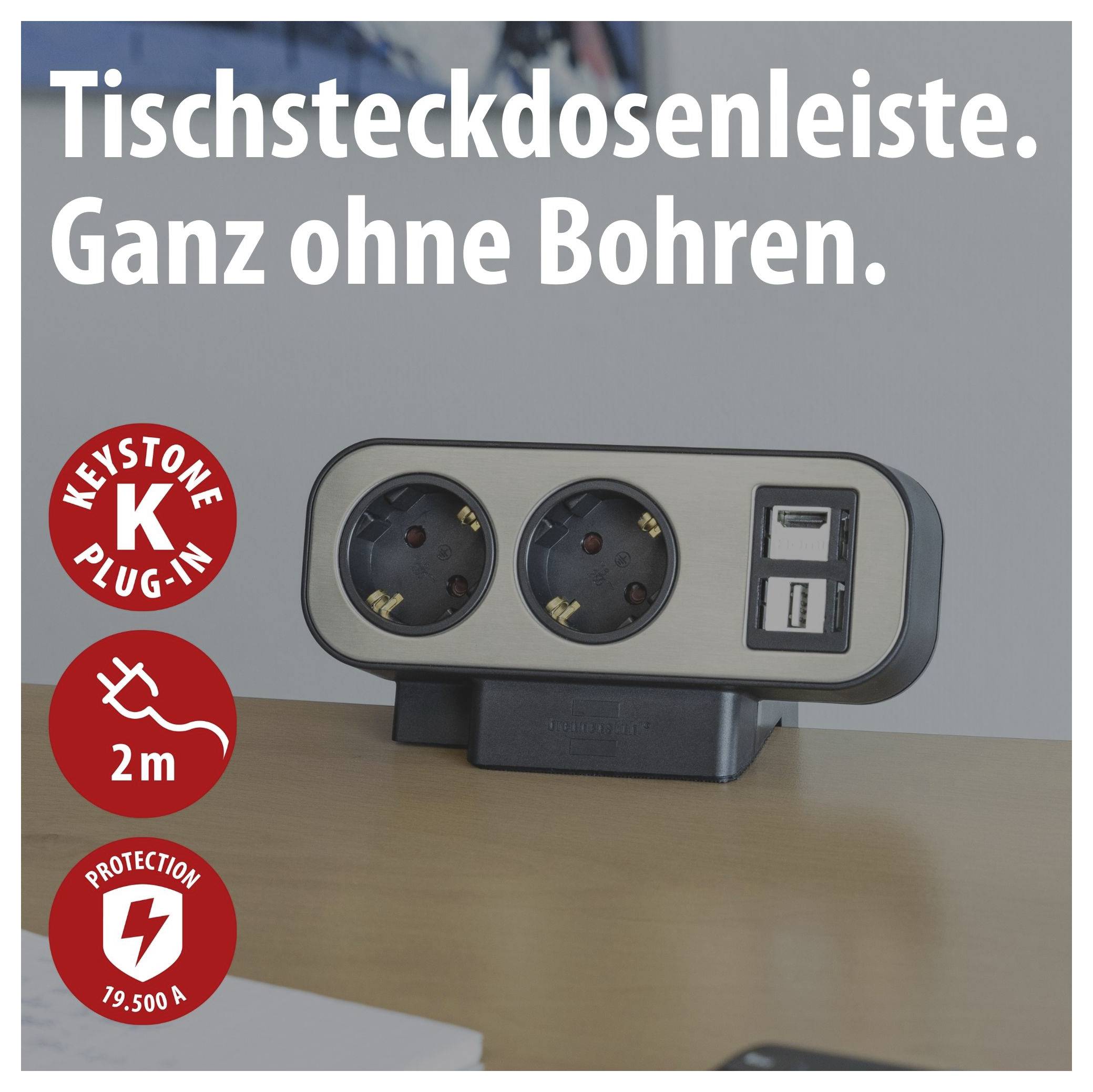 Steckdosenleiste mit zwei Steckdosen und zwei USB-Anschlüssen auf dem Tisch; Text: 'Steckdosenleiste. Ganz ohne Bohren.' sowie Symbole für Keystone Plug-in, 2 m Kabel und Schutz 19.500 A.