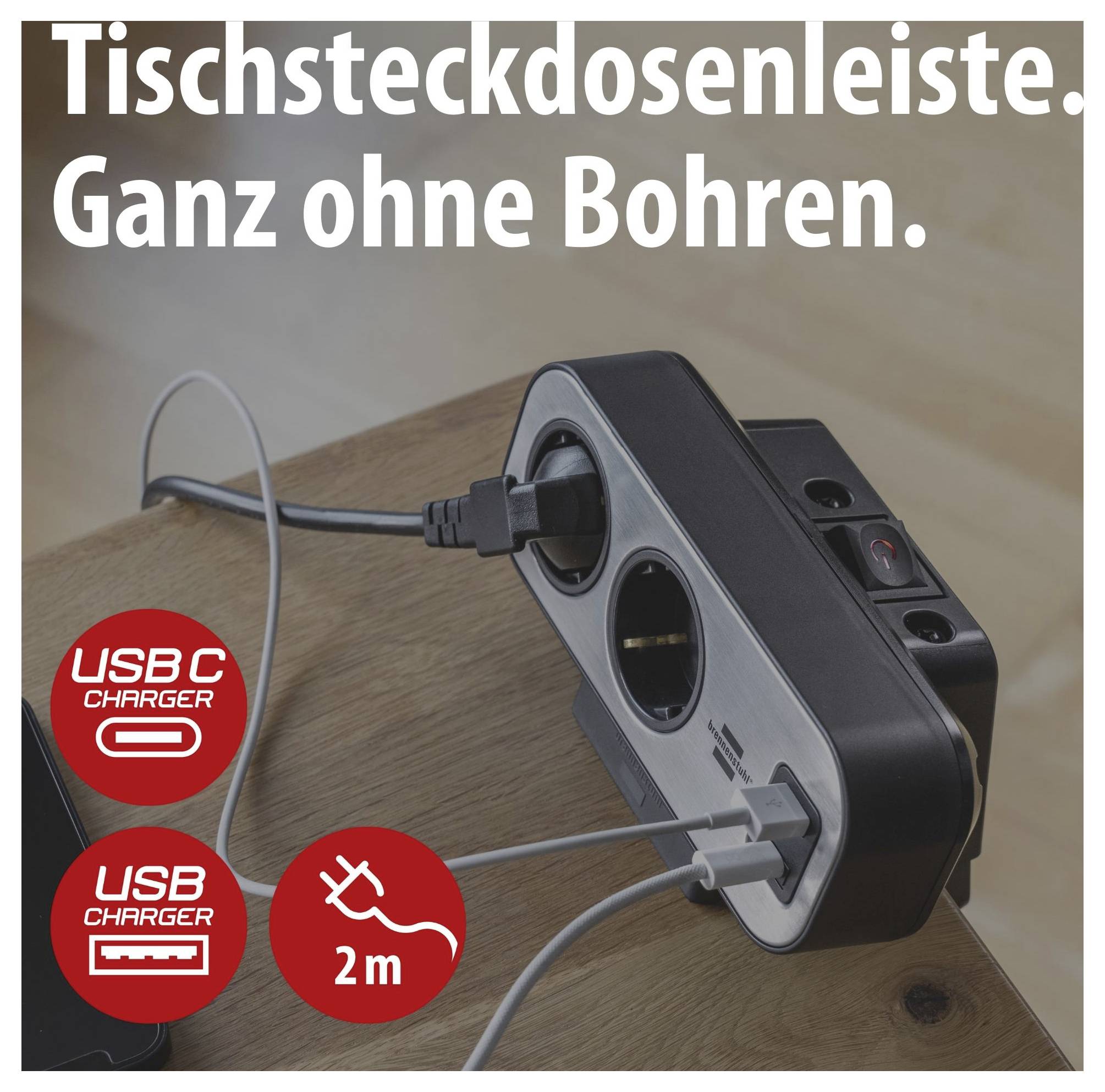 Werbebild einer Tischsteckdosenleiste mit zwei USB-Anschlüssen, 'Ganz ohne Bohren', auf einem Holztisch mit eingesteckten Kabeln; Icons zeigen USB-C, USB und 2 m.