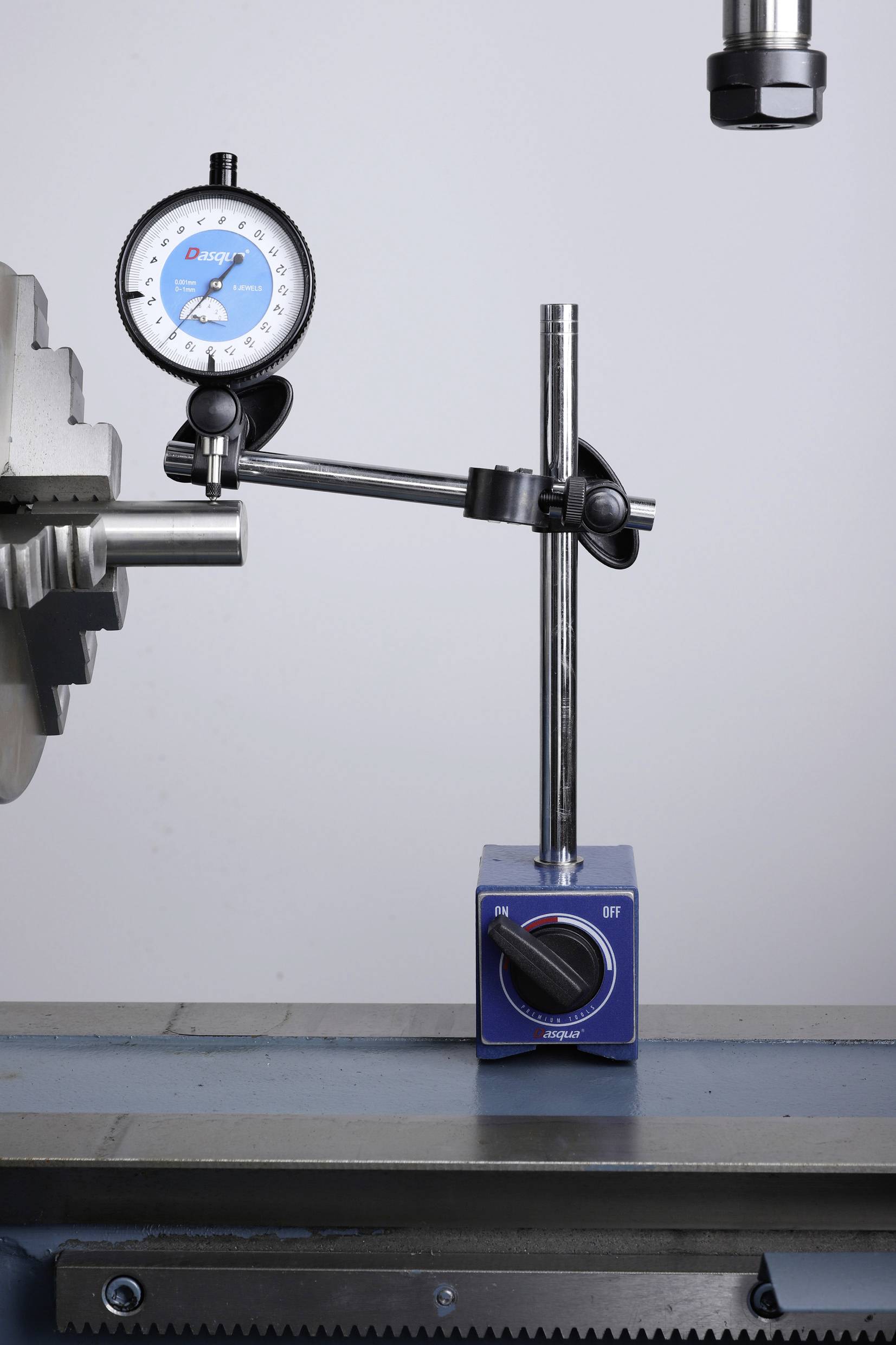 Messuhr auf starrer Halterung misst beweglichen Metallzylinder. Präzisionsinstrument zur Bestimmung von Dimensionen.