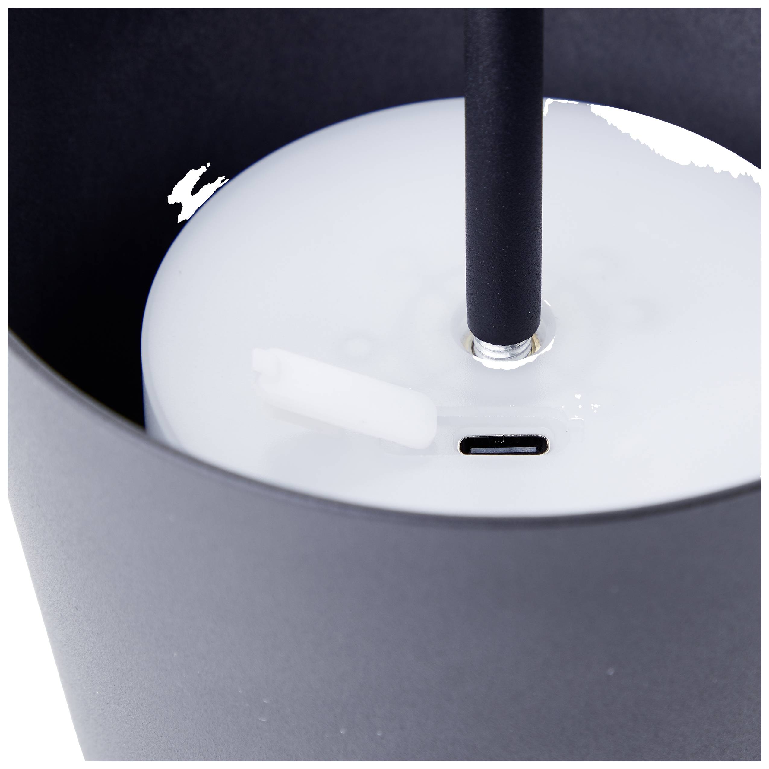 Schwarzes, rundes Gerät mit Strohhalm und USB-C-Anschluss auf weißem Hintergrund. Gerät ist teilweise mit weiße Flüssigkeit bedeckt.