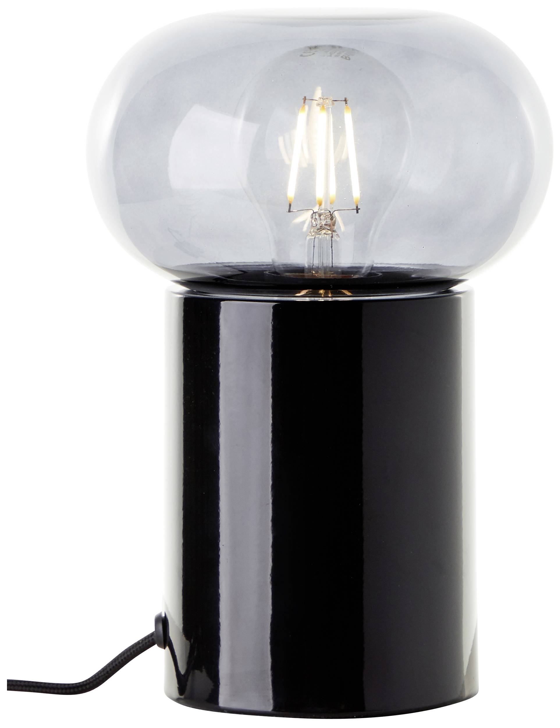 Eine moderne Tischlampe mit schwarzem, zylindrischem Sockel und einer großen, durchsichtigen Glühbirne, die eingeschaltet ist.