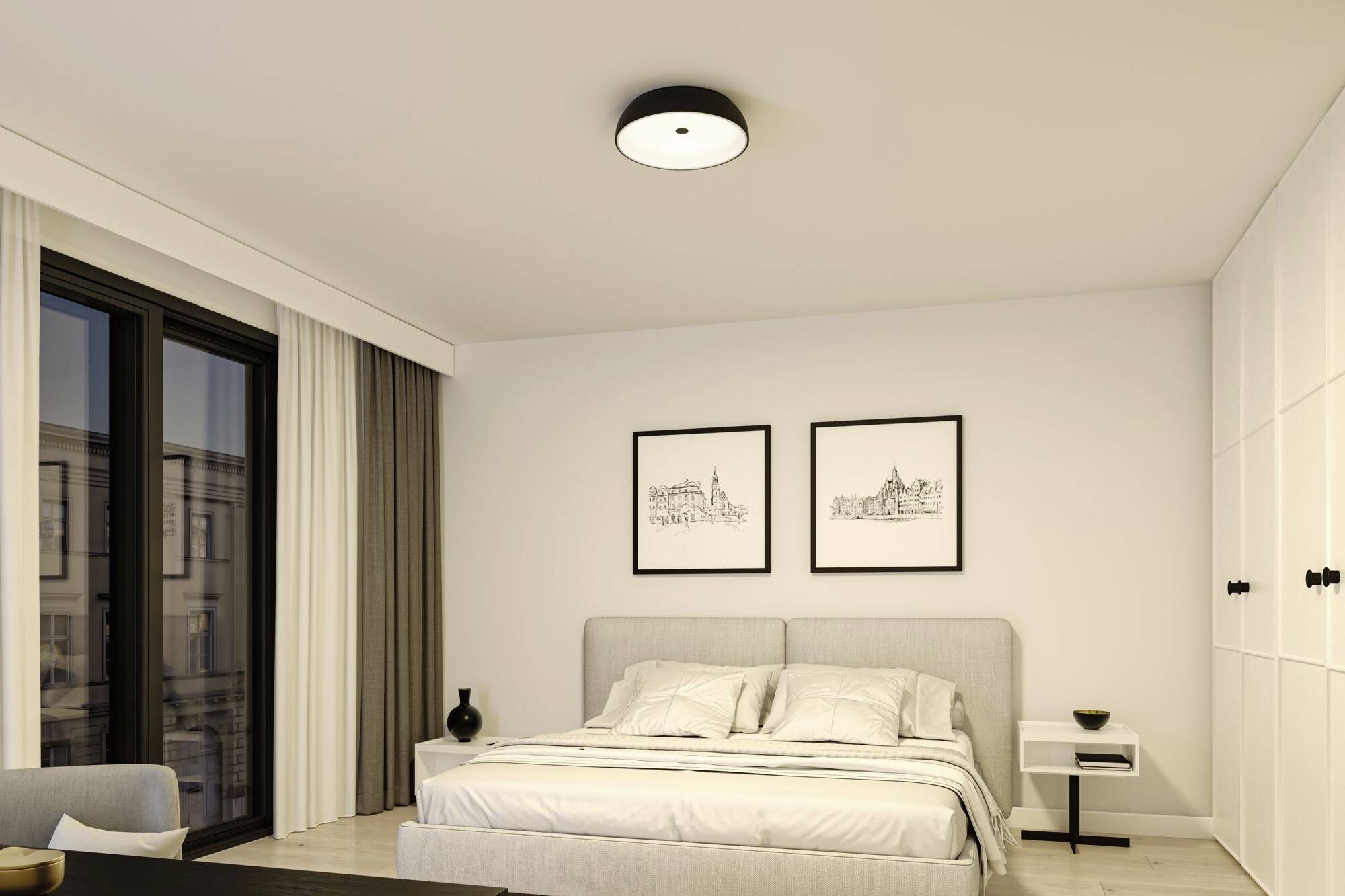 Modernes Schlafzimmer mit einem großen Bett, zwei Bilder an der Wand, Fenster mit Vorhängen, und einem Nachttisch mit Lampe.