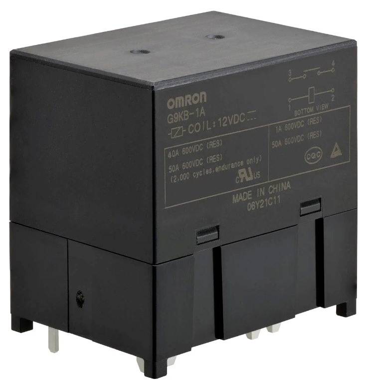 Ein schwarzes, rechteckiges elektrisches Relais mit mehreren Metallstiften an der Unterseite und technischen Spezifikationen auf der Oberseite.