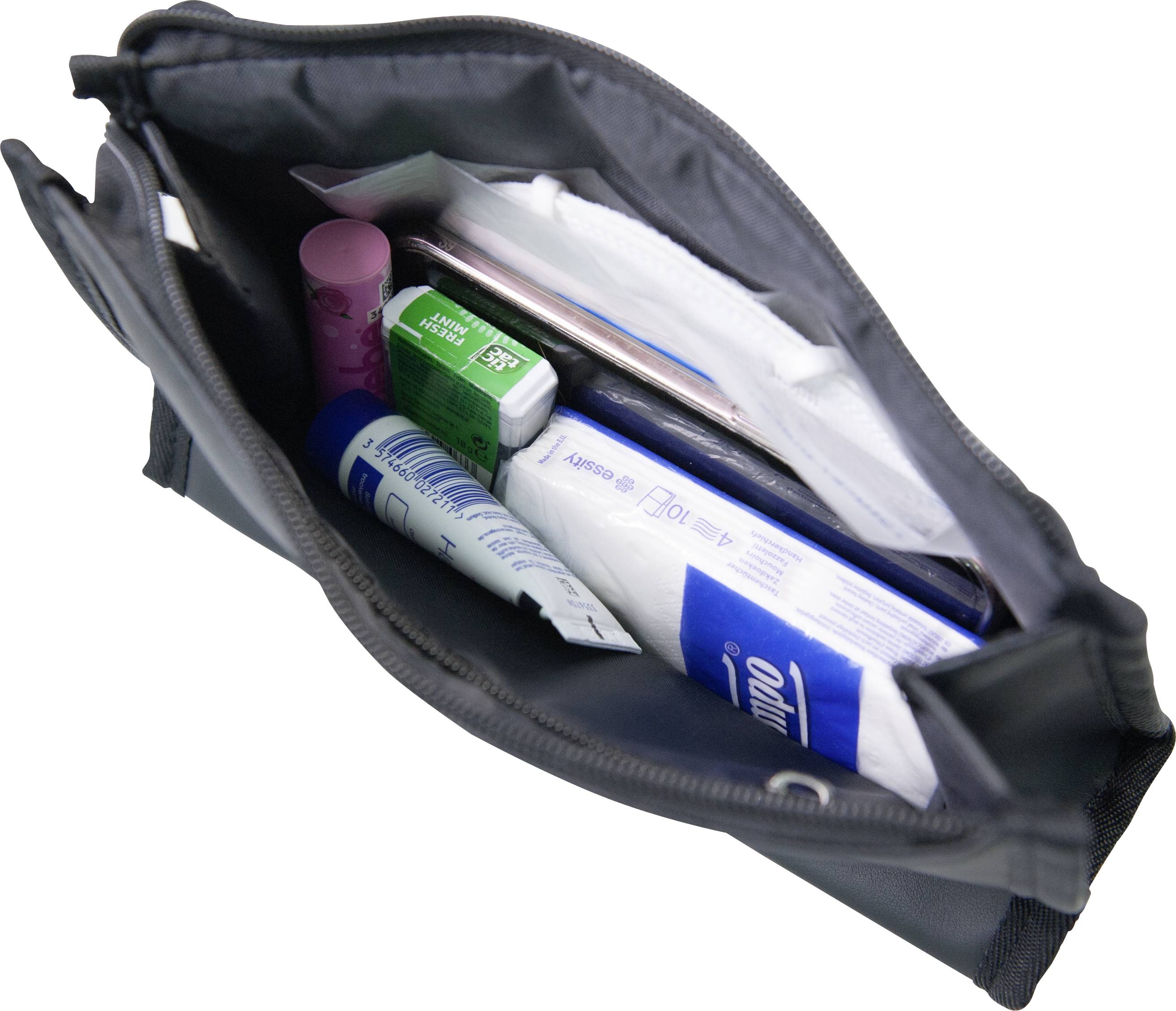 Eine geöffnete Tasche mit Hygieneartikeln: Zahnpasta, Mundspülung, Lippenbalsam, Papiertaschentücher und Zahnbürste.